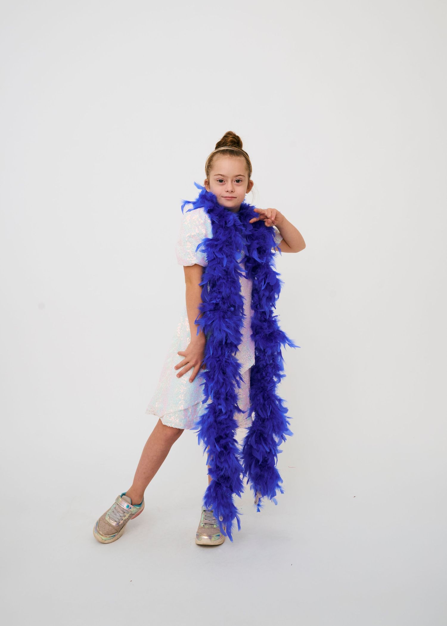 Four dance poses showing a performer in white top and blue feather boa against a white studio background.