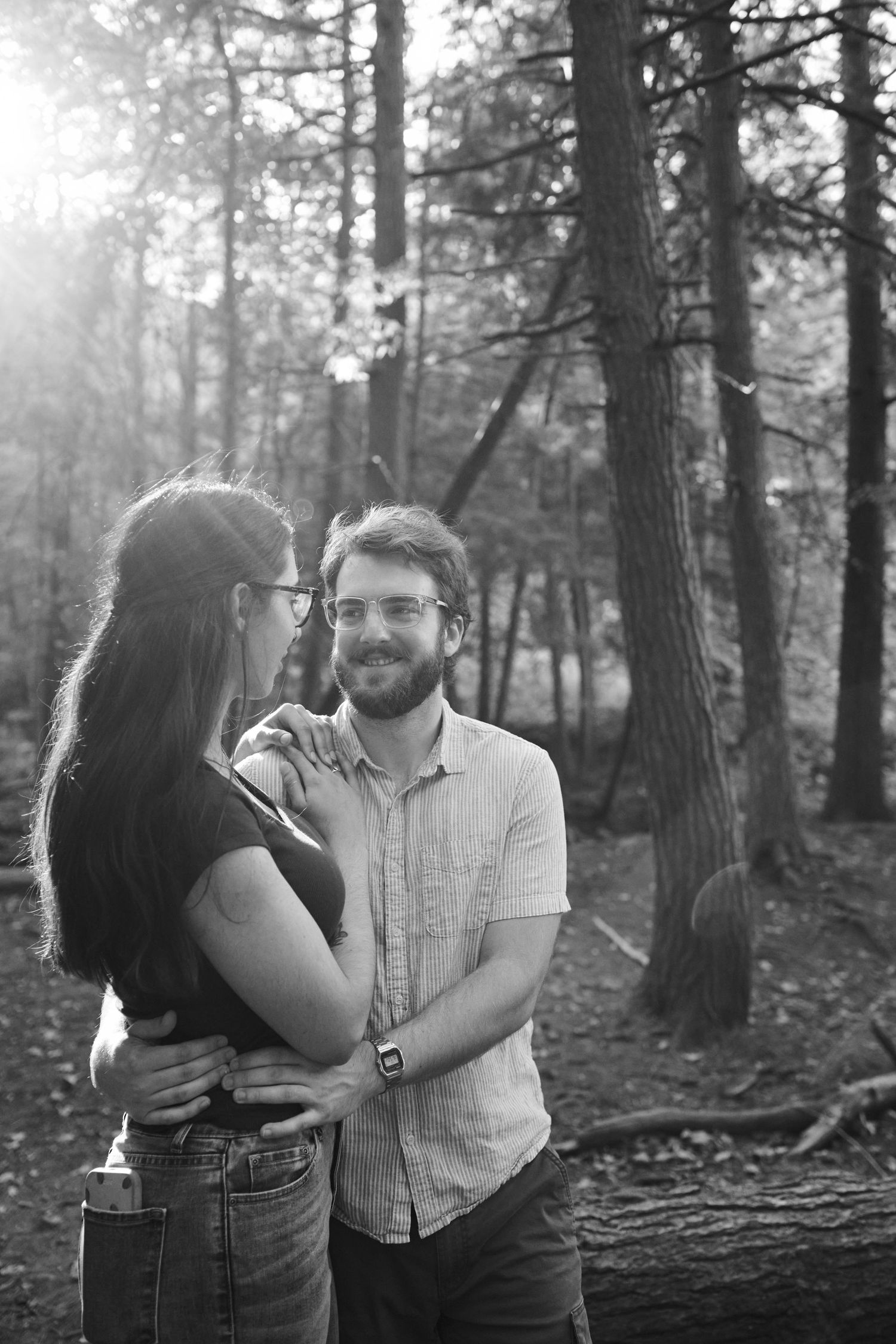 A romantic black and white photo series showing a couple embracing in a misty forest setting.