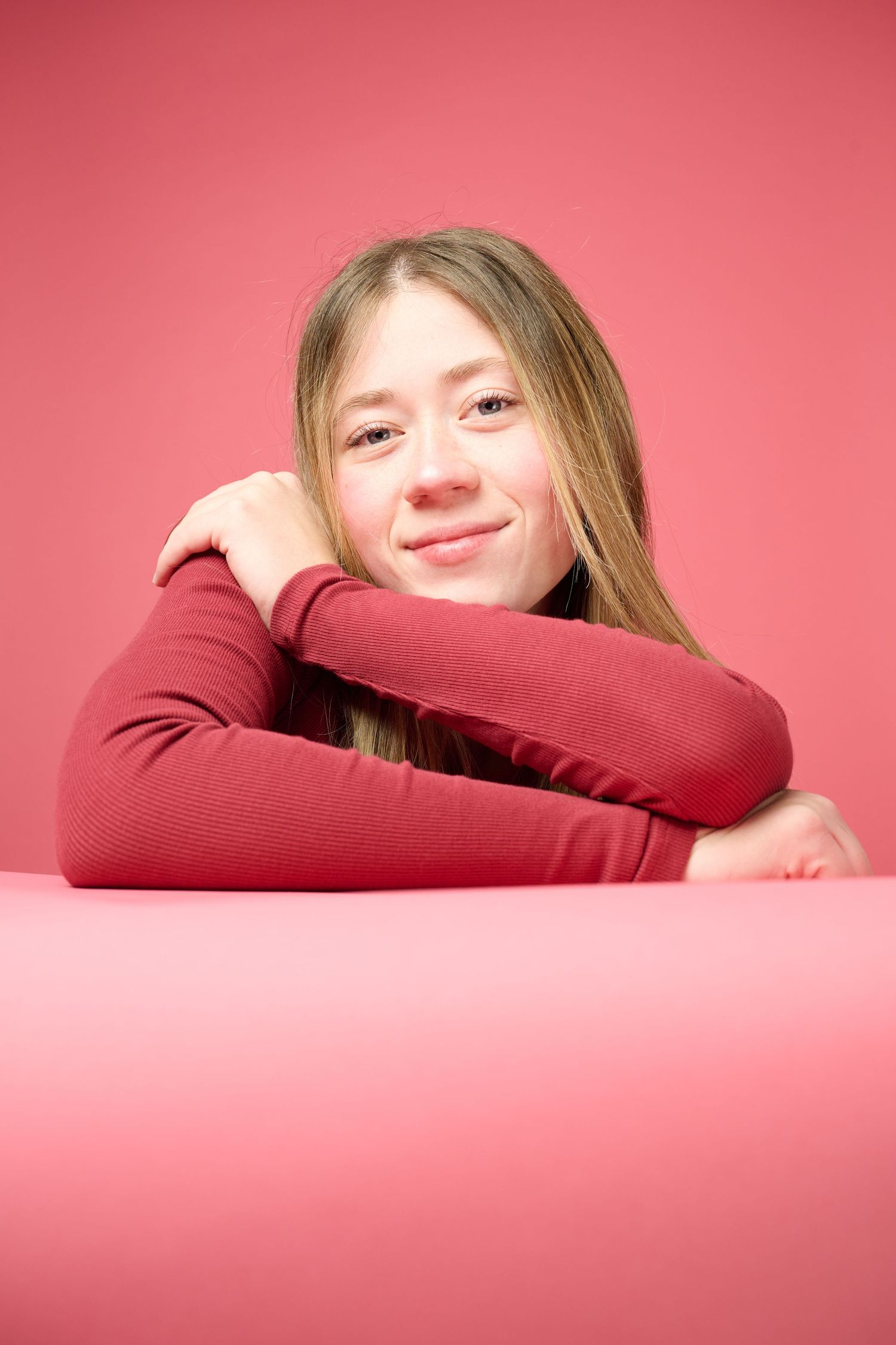 A series of four photos showing someone resting their head on crossed arms against a pink background.