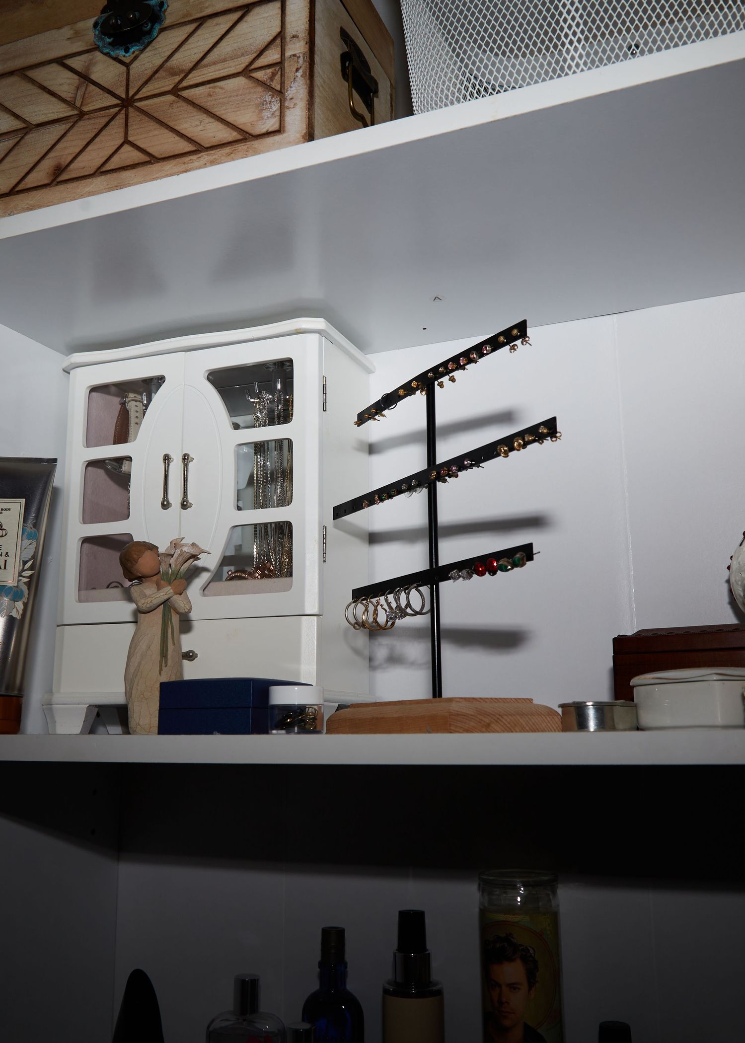 Storage shelf with jewelry display stands and decorative items.