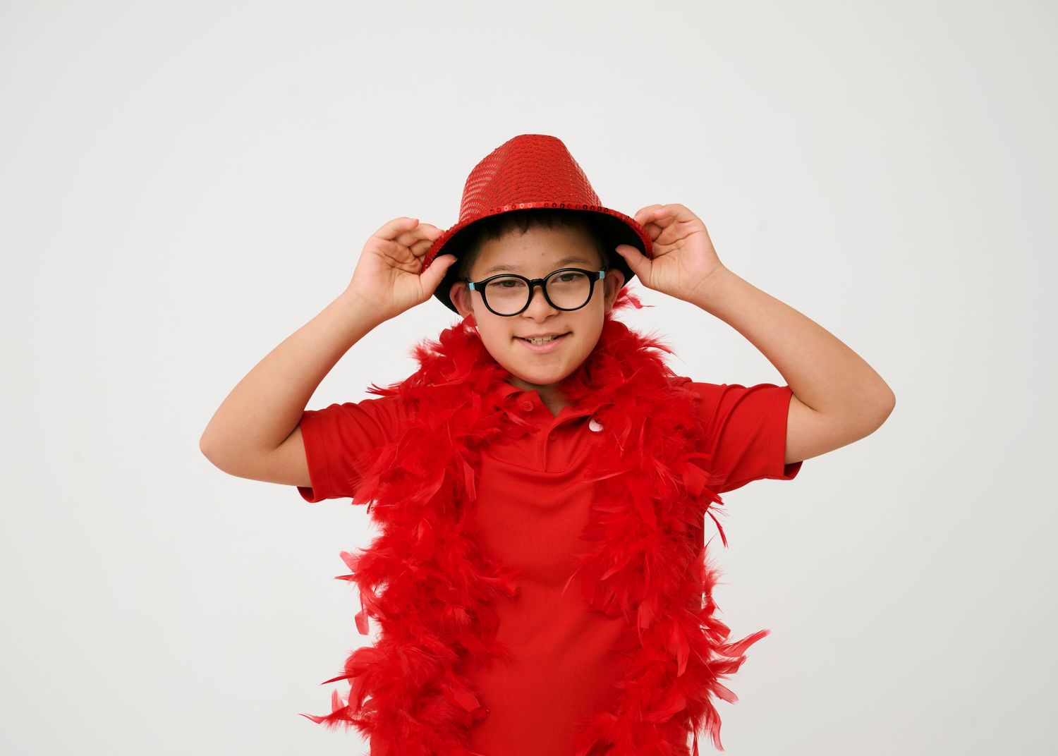 Person wearing glasses and red feather boa poses playfully in sequence of four connected photos.