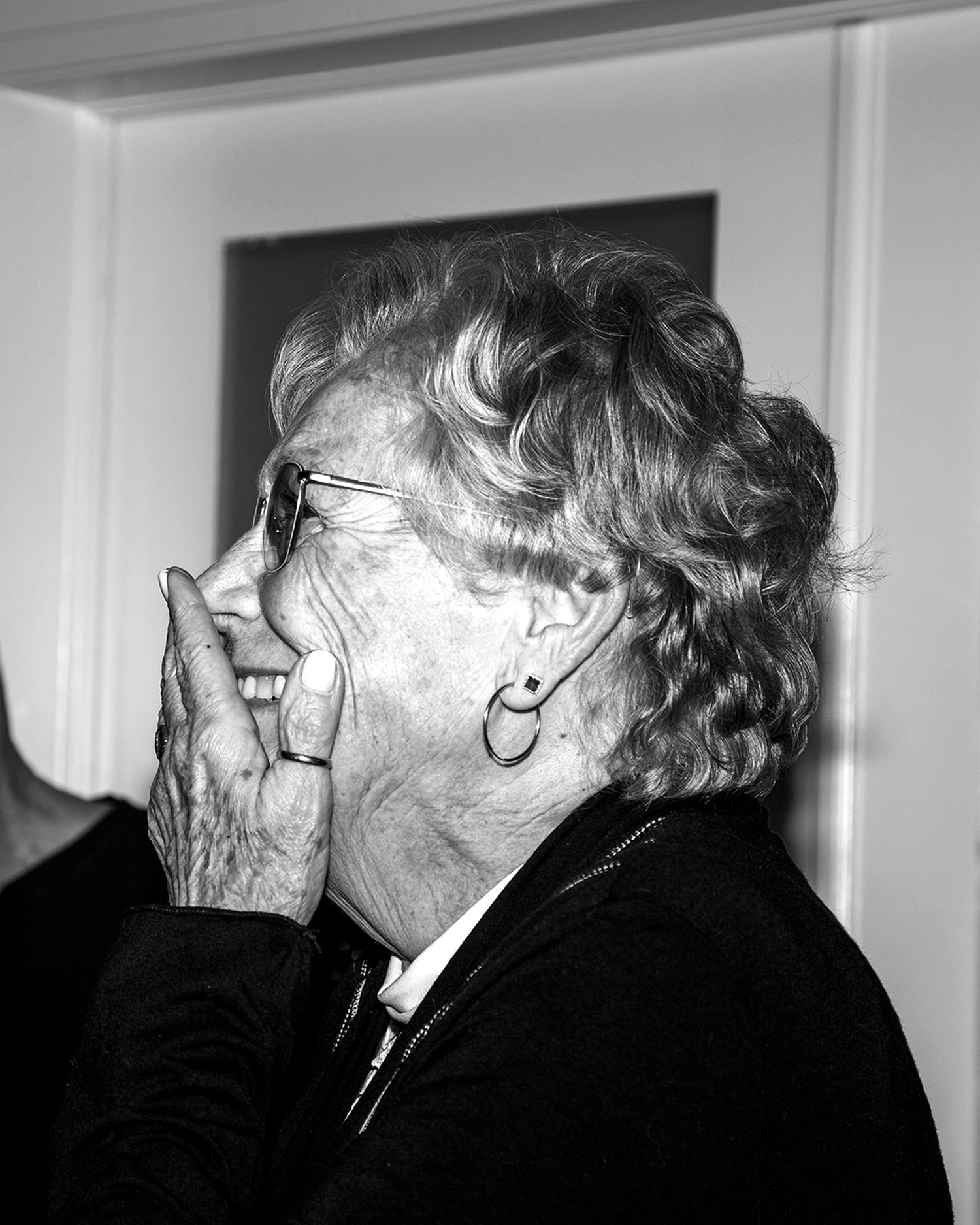 Black and white profile portrait showing laughter and genuine emotion.