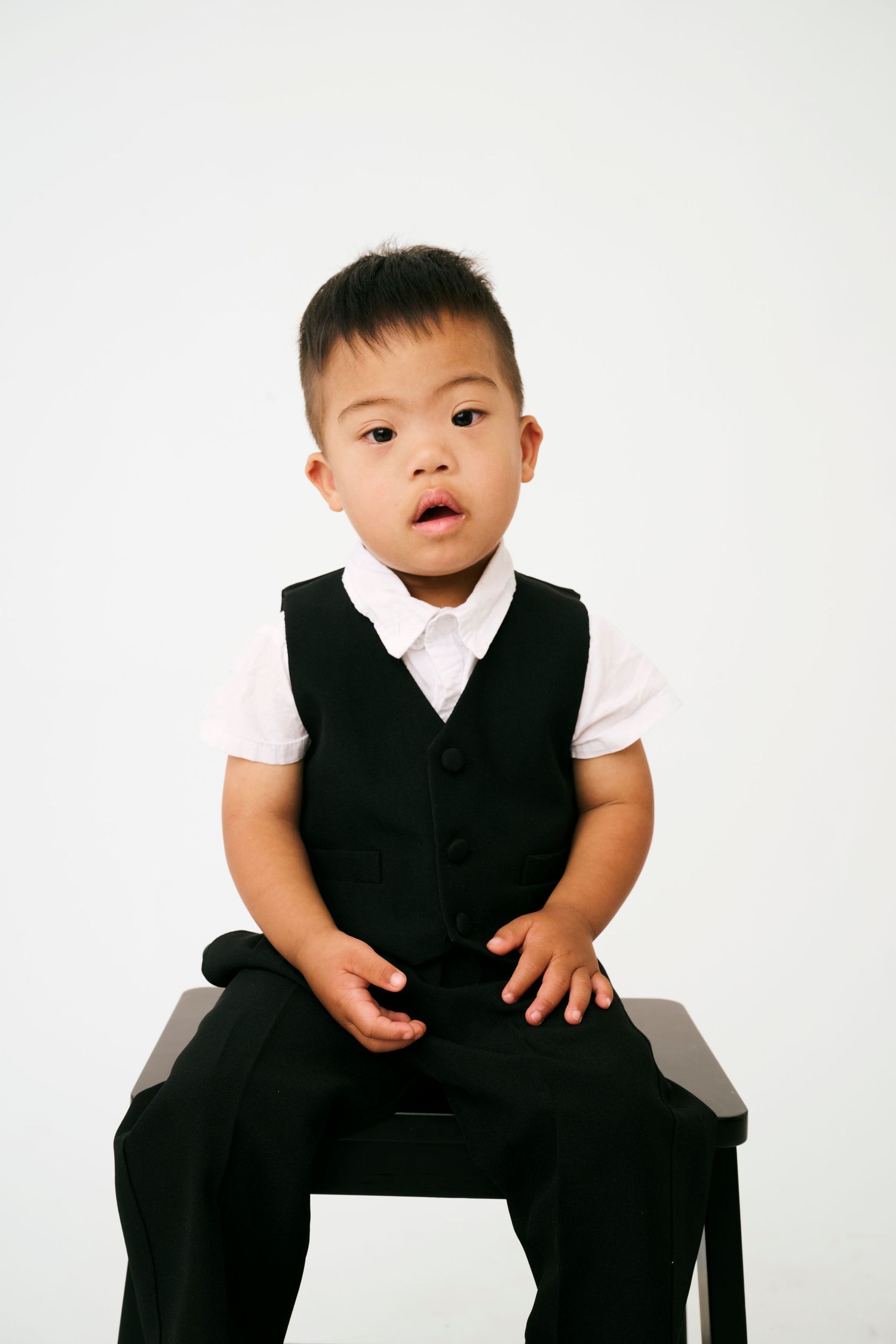 A series showing a young person in formal black and white attire posing on a white background.