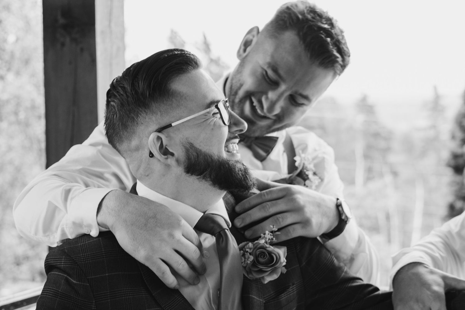 Two people sharing an intimate moment while laughing at a wedding celebration.