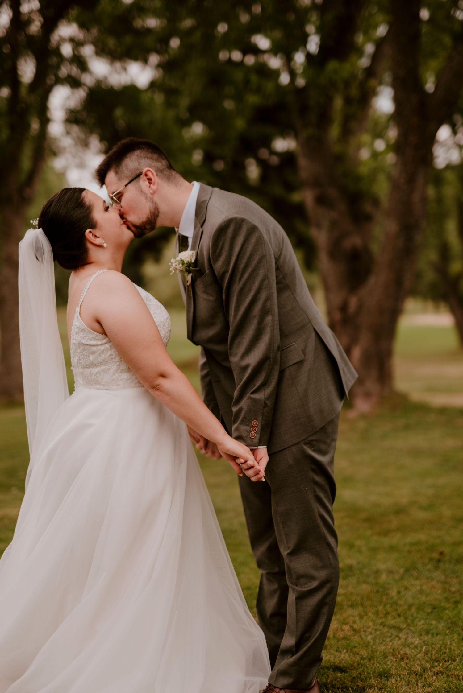 Tender moment between newlyweds sharing a kiss on their wedding day.