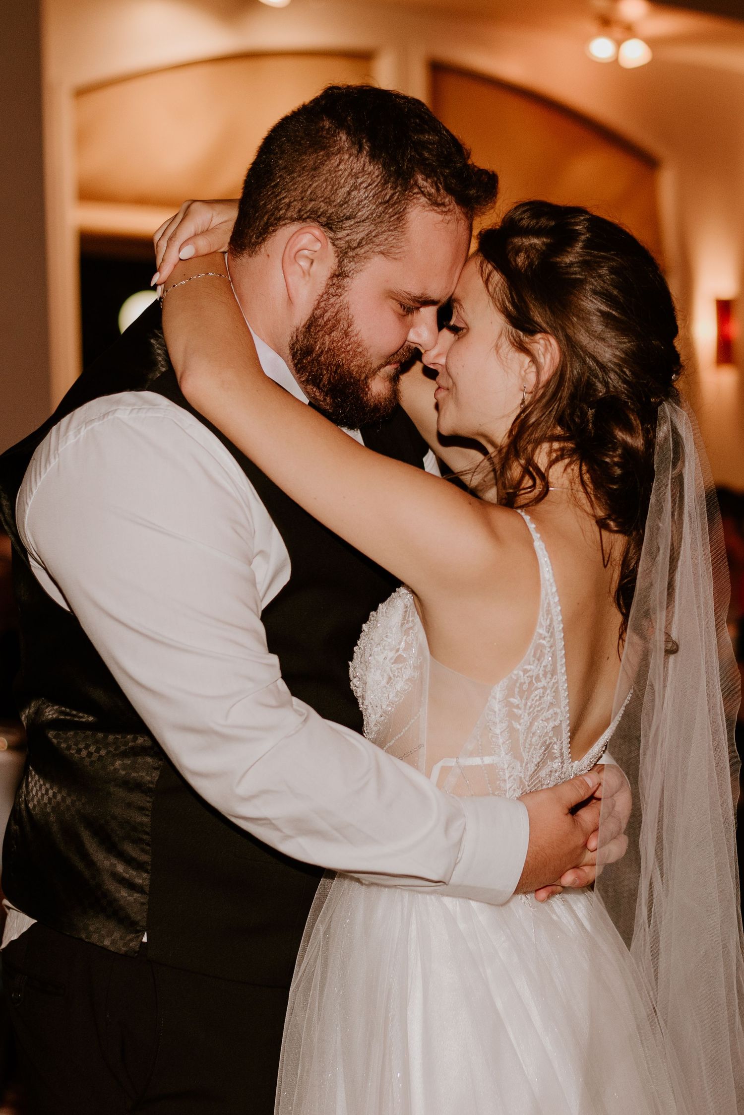 A romantic moment between newlyweds during their wedding reception.