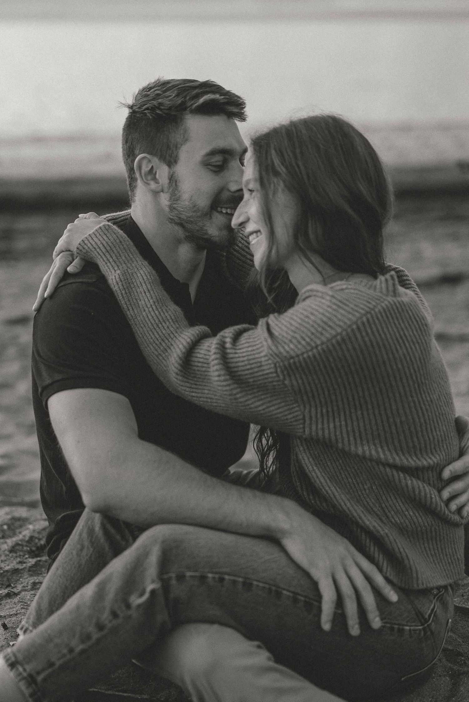 Un couple amoureux s'enlaçant sur la plage de Rimouski