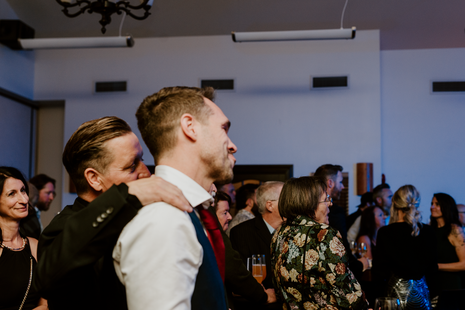 Wedding guests celebrate and dance together during a lively reception party.