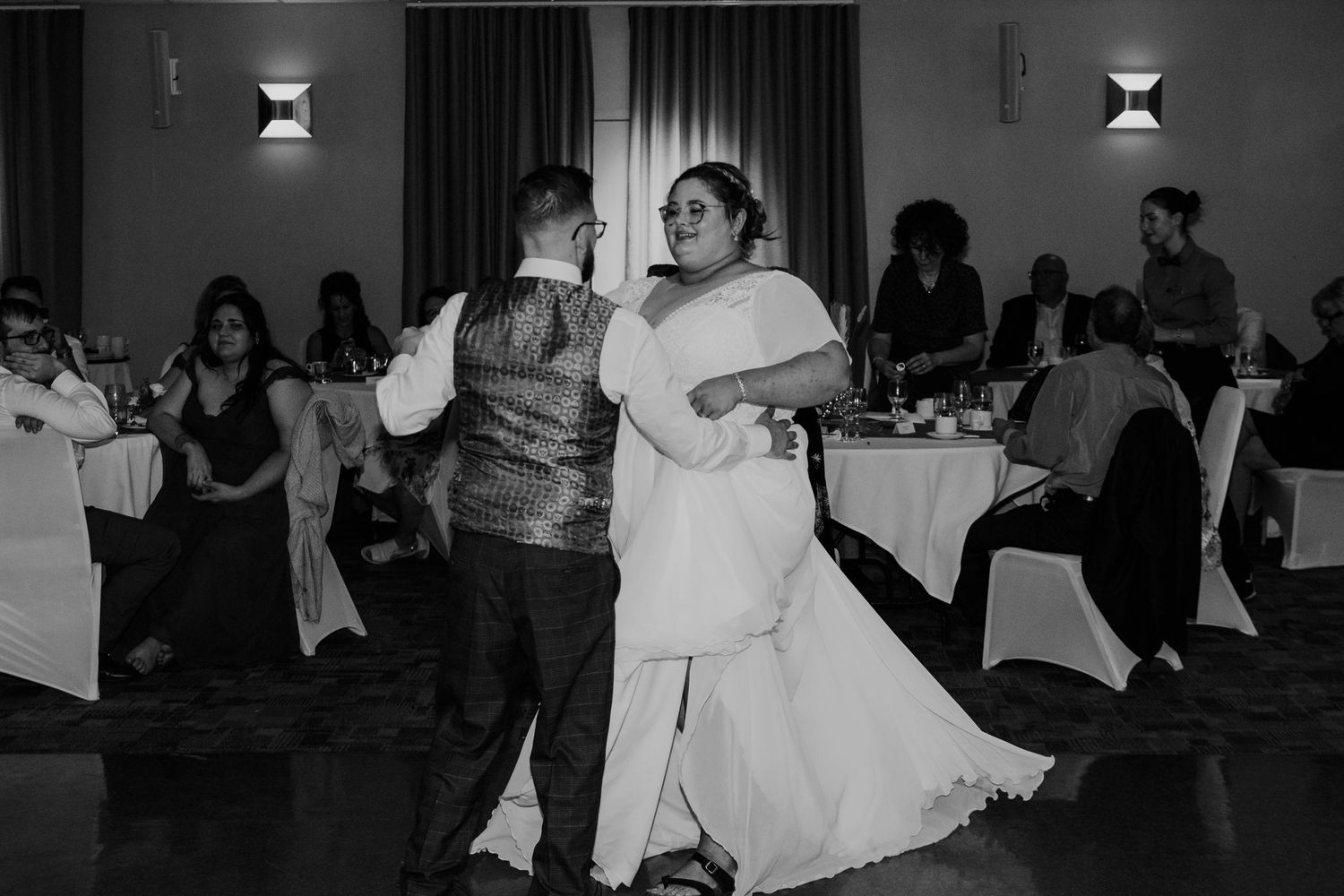 Couple dancing together at their wedding reception in black and white.