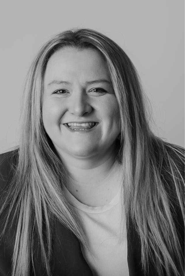 Professional headshot of a woman in business attire smiling at the camera.