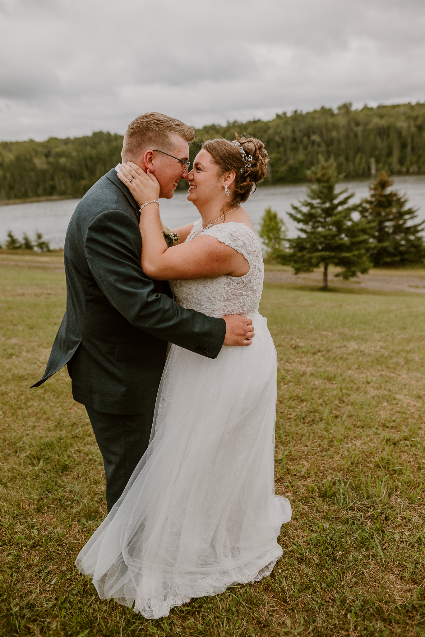 A romantic wedding portrait captures a couple sharing a tender moment in a scenic outdoor setting.