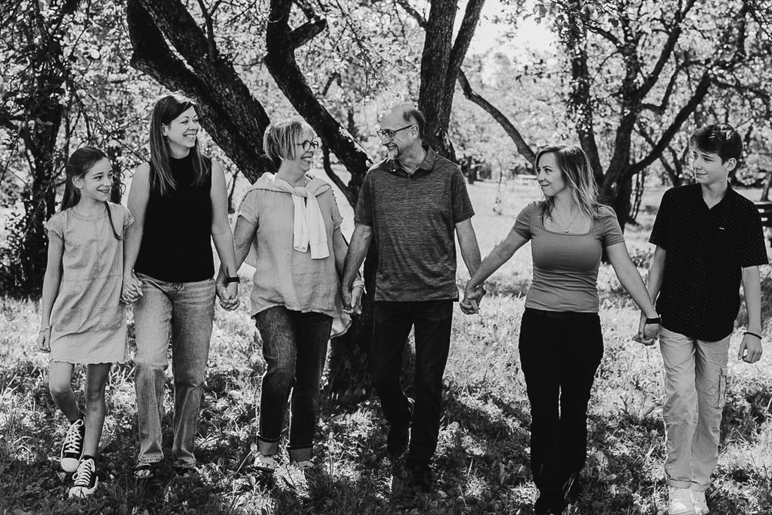 A group walking together on a wooded path in black and white photography.