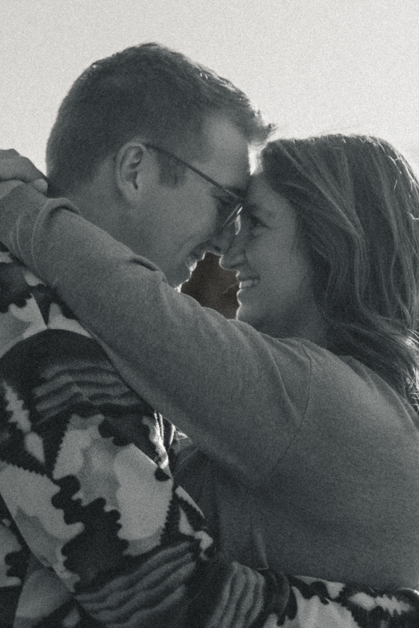 A romantic black and white photo sequence showing a couple embracing and leaning in for a tender kiss.