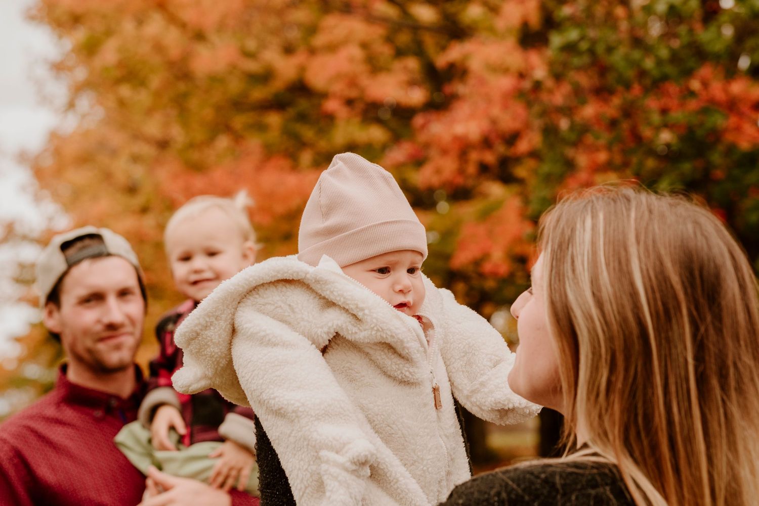 Une famille partage un moment tendre et authentique dans un décor automnal, vif et chaleureux.