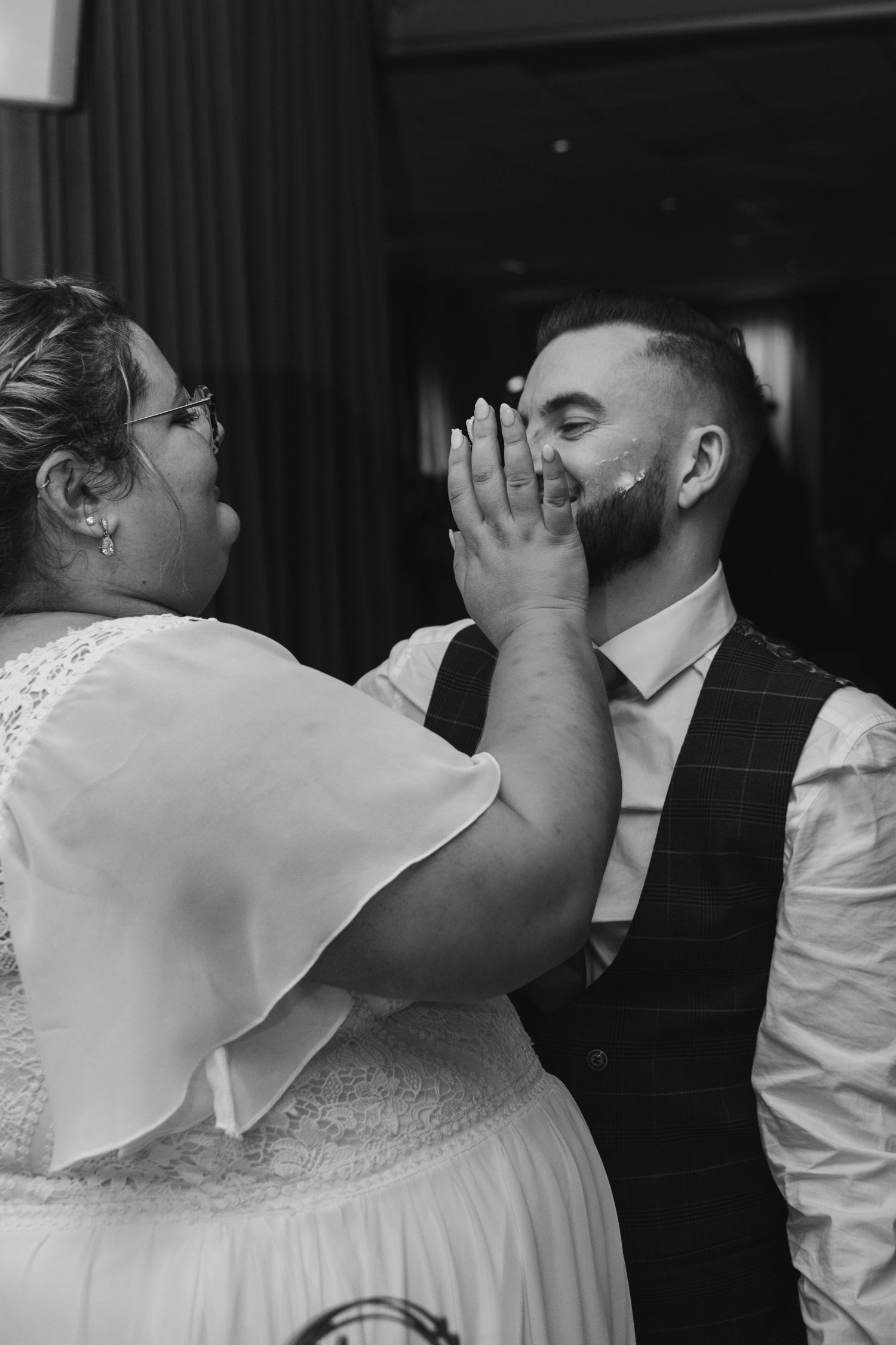 Joyful moment between couple sharing laughter at their wedding reception.