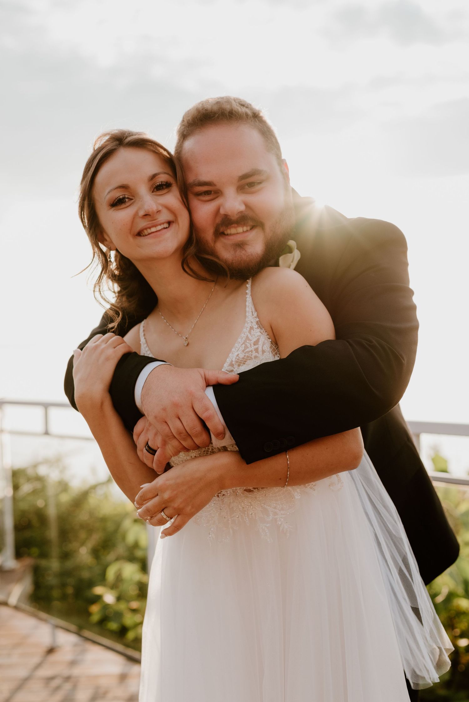 Romantic sunset portrait of newlyweds embracing outdoors.