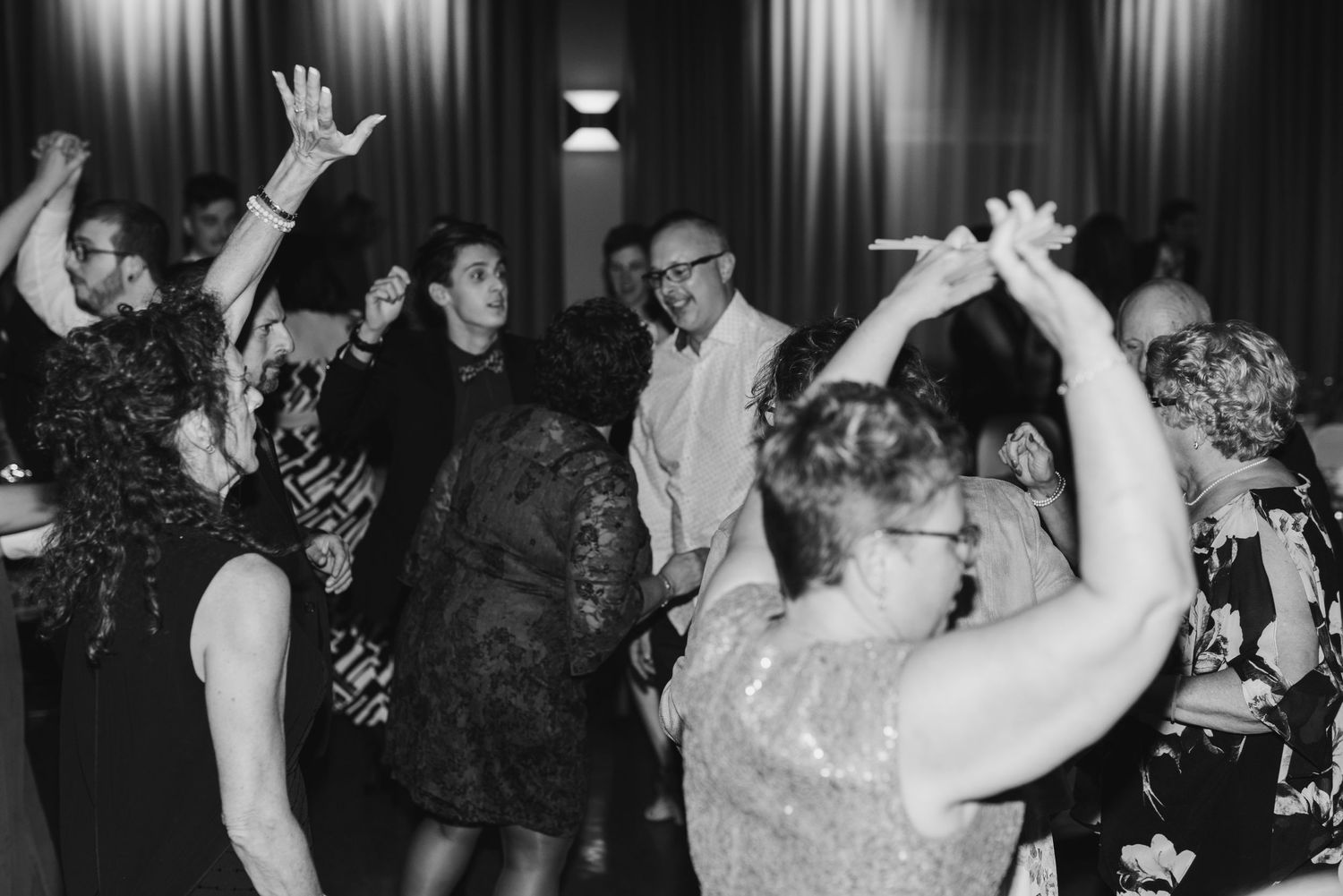 Wedding guests dancing enthusiastically on the reception dance floor.