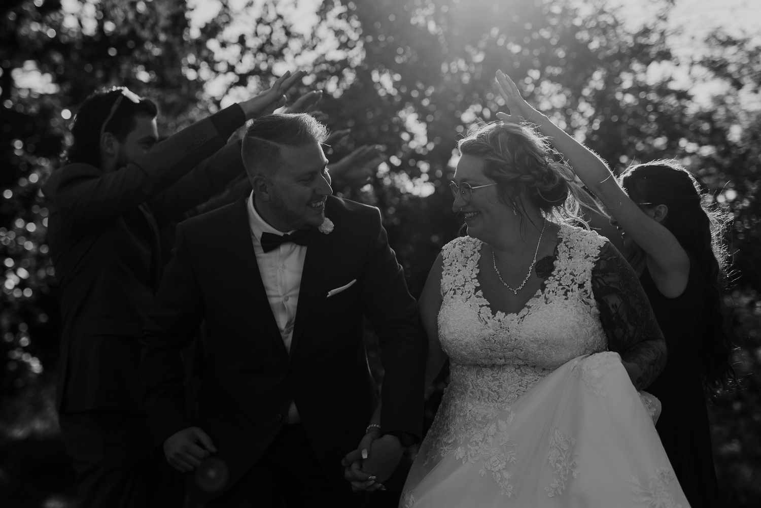 Une photo authentique d'un couple complice lors de leur cérémonie en plein air, le tout capté en noir et blanc.