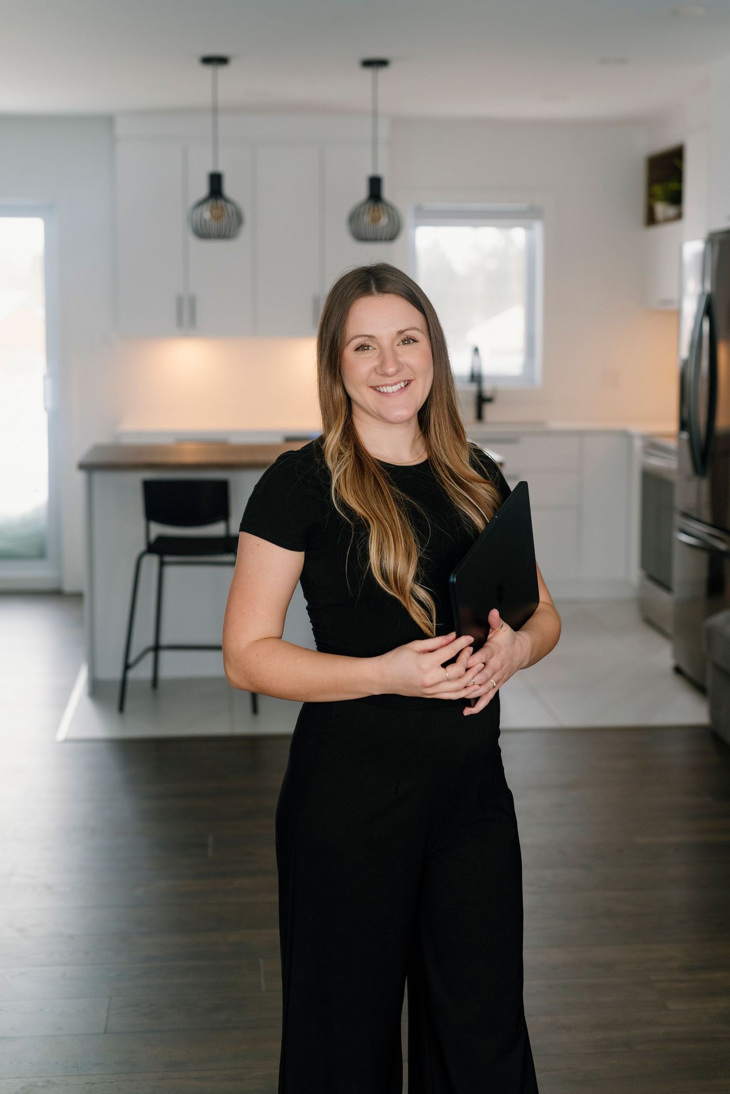 Dans une cuisine lumineuse, une femme d'affaires prend la pose pour une séance photo d'entreprise.