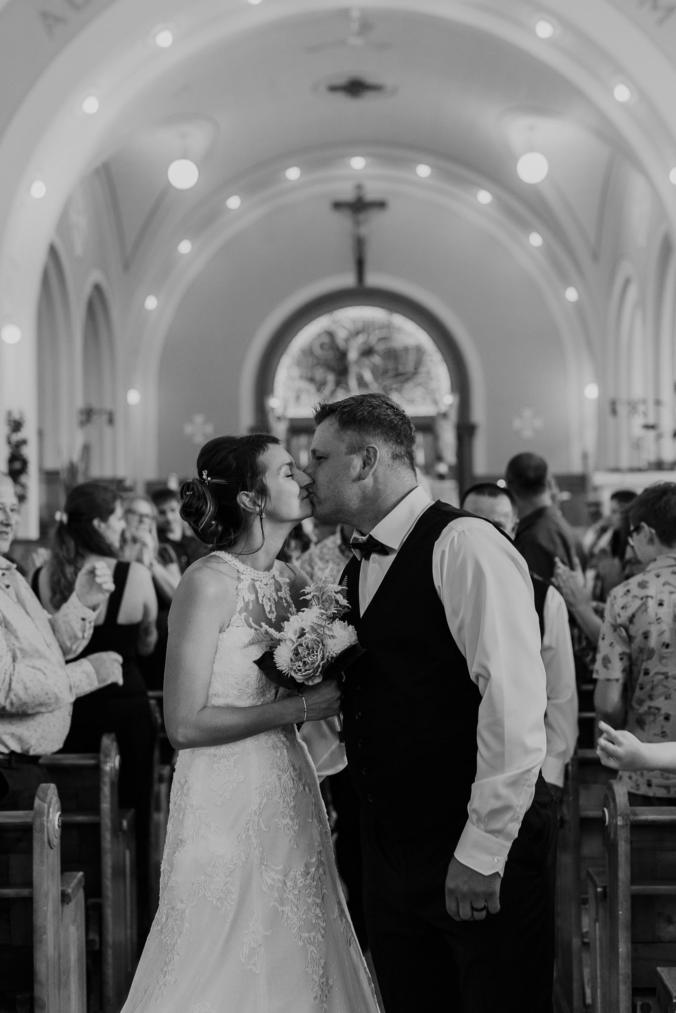 Intimate moment captured in black and white inside a traditional church with vaulted ceilings.