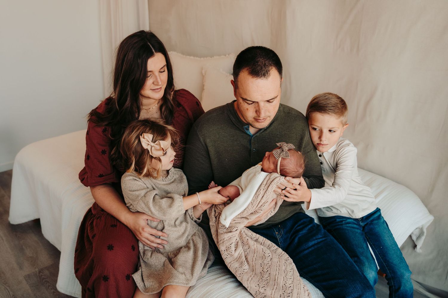 Cozy family lifestyle session on a cream-colored couch with soft natural lighting.