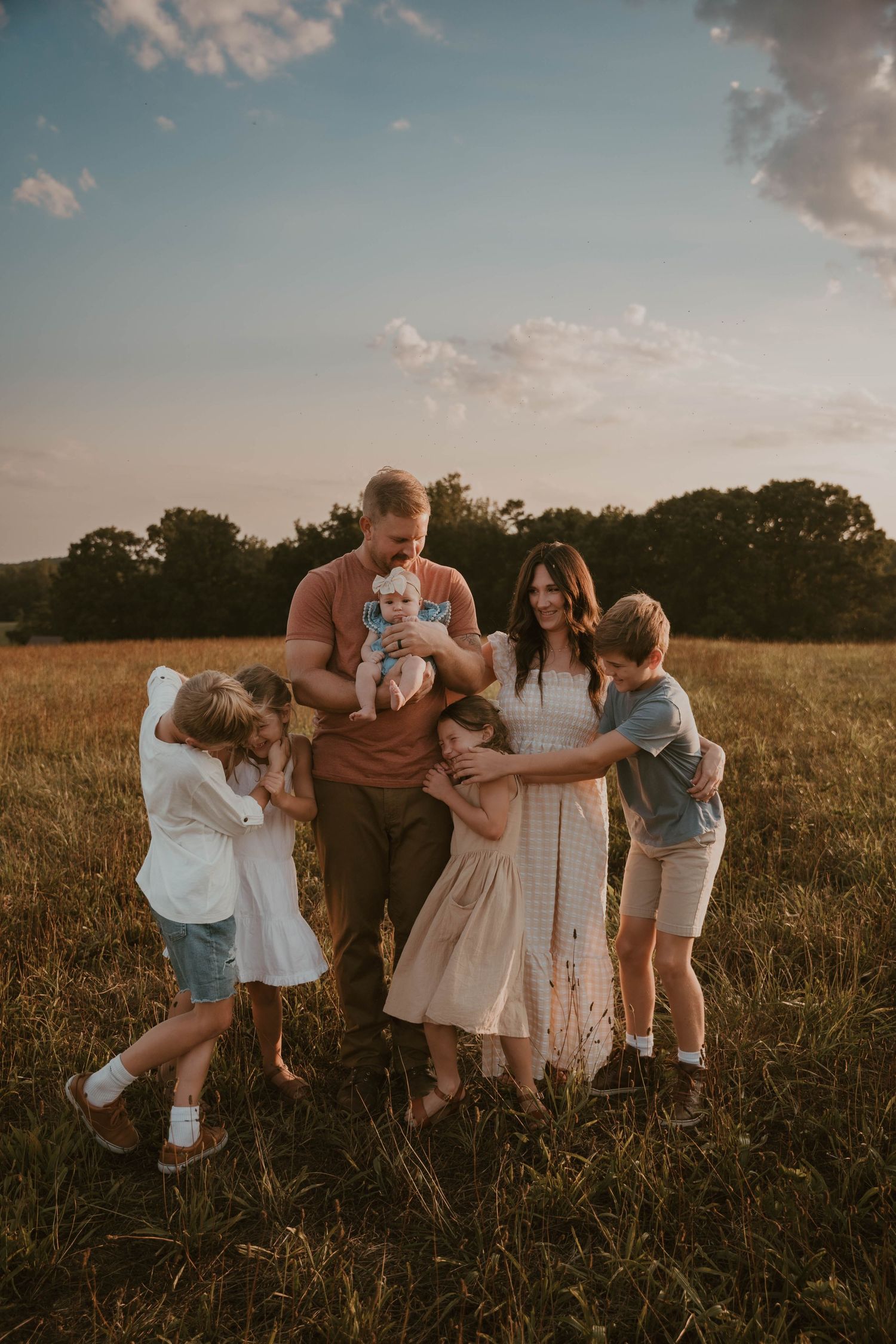 Sunset family photoshoot in a golden field with warm summer light.