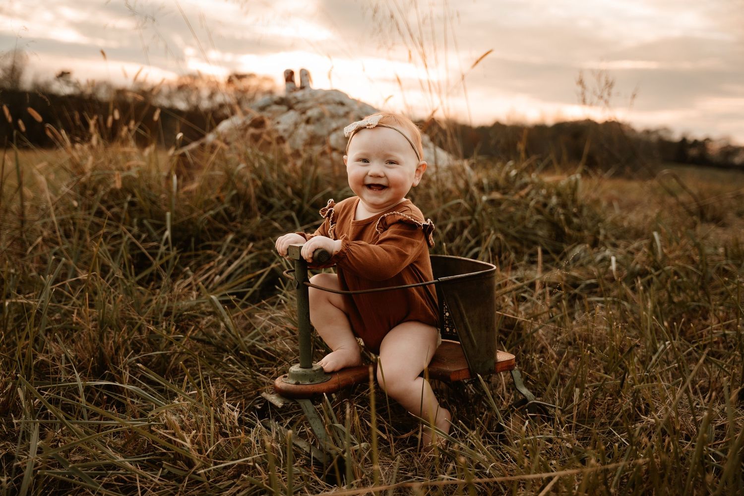 Happy baby exploring outdoors in natural setting during golden hour.