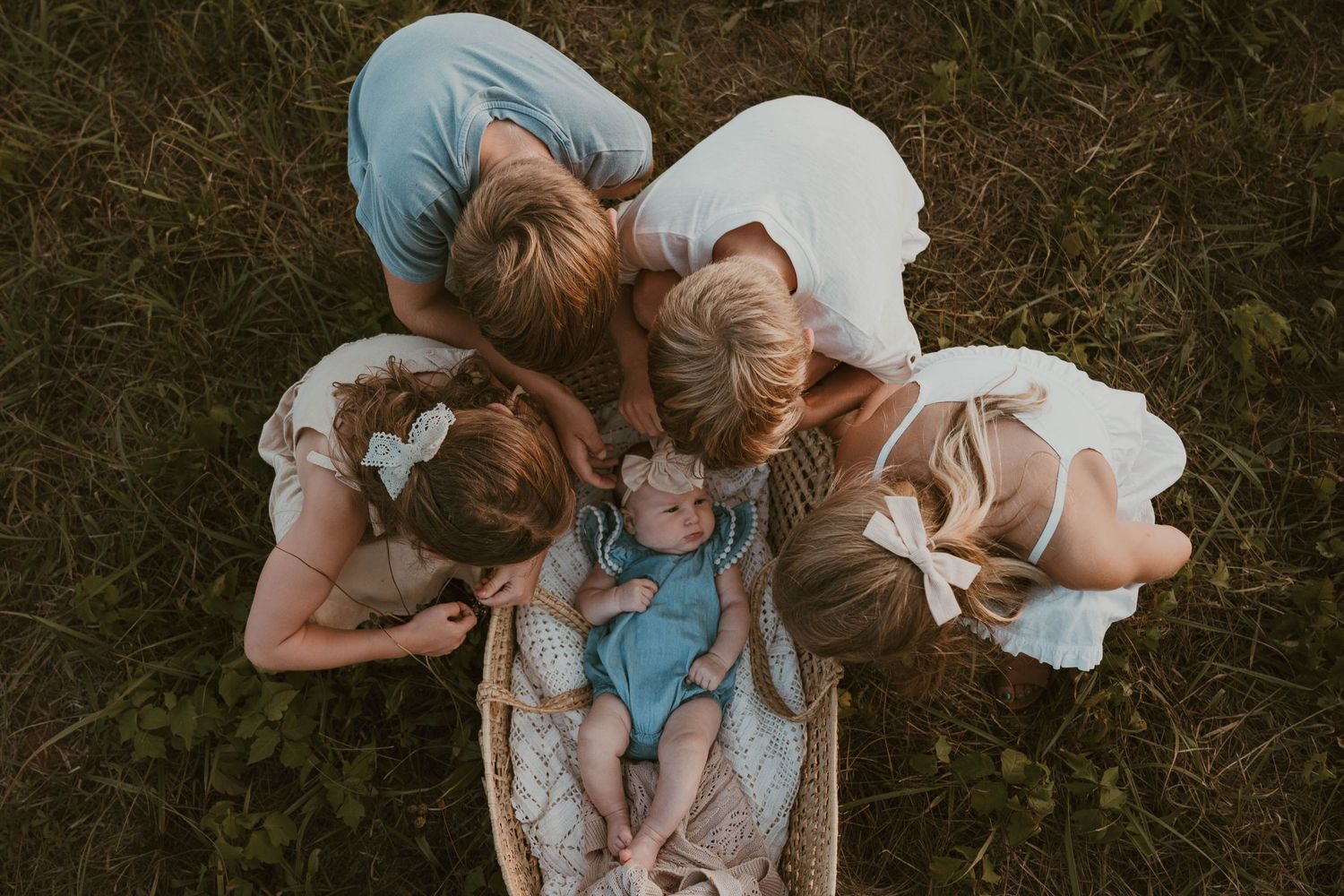 Overhead view of family lying in grass forming a circle.
