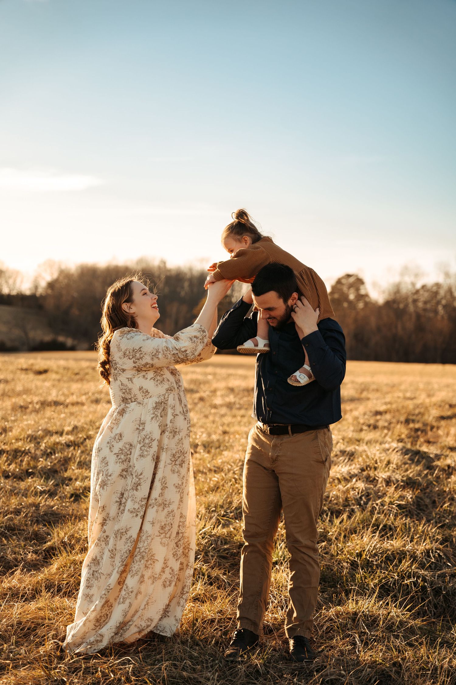 A joyful family moment captured in golden sunlight on an autumn field.