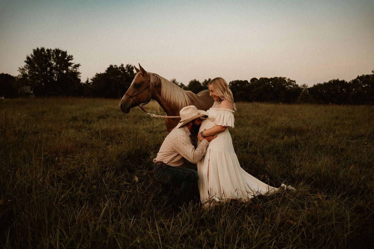 Romantic countryside photoshoot with horse in field at sunset.