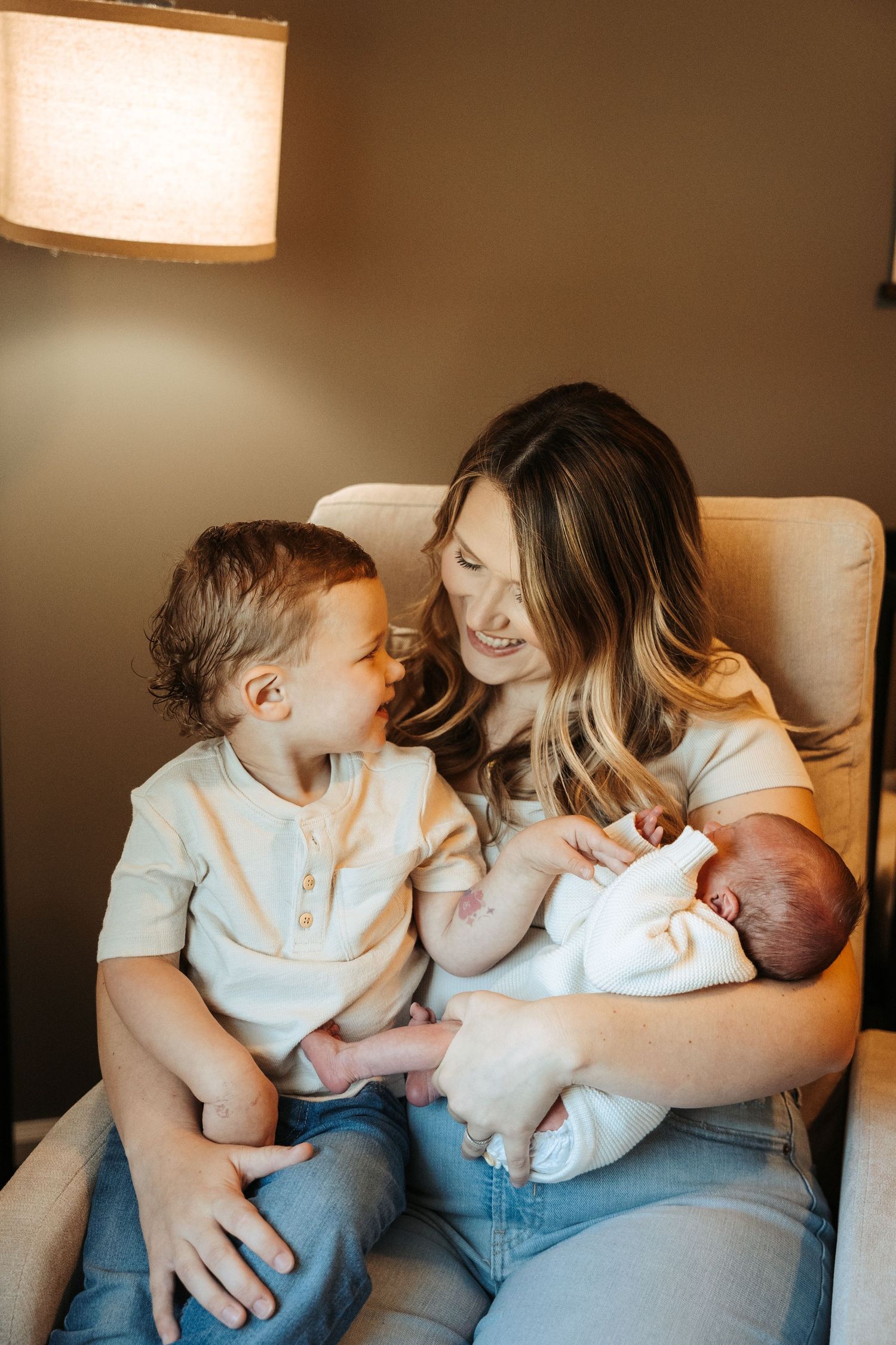 Indoor lifestyle photography capturing sweet family interactions in warm lighting.