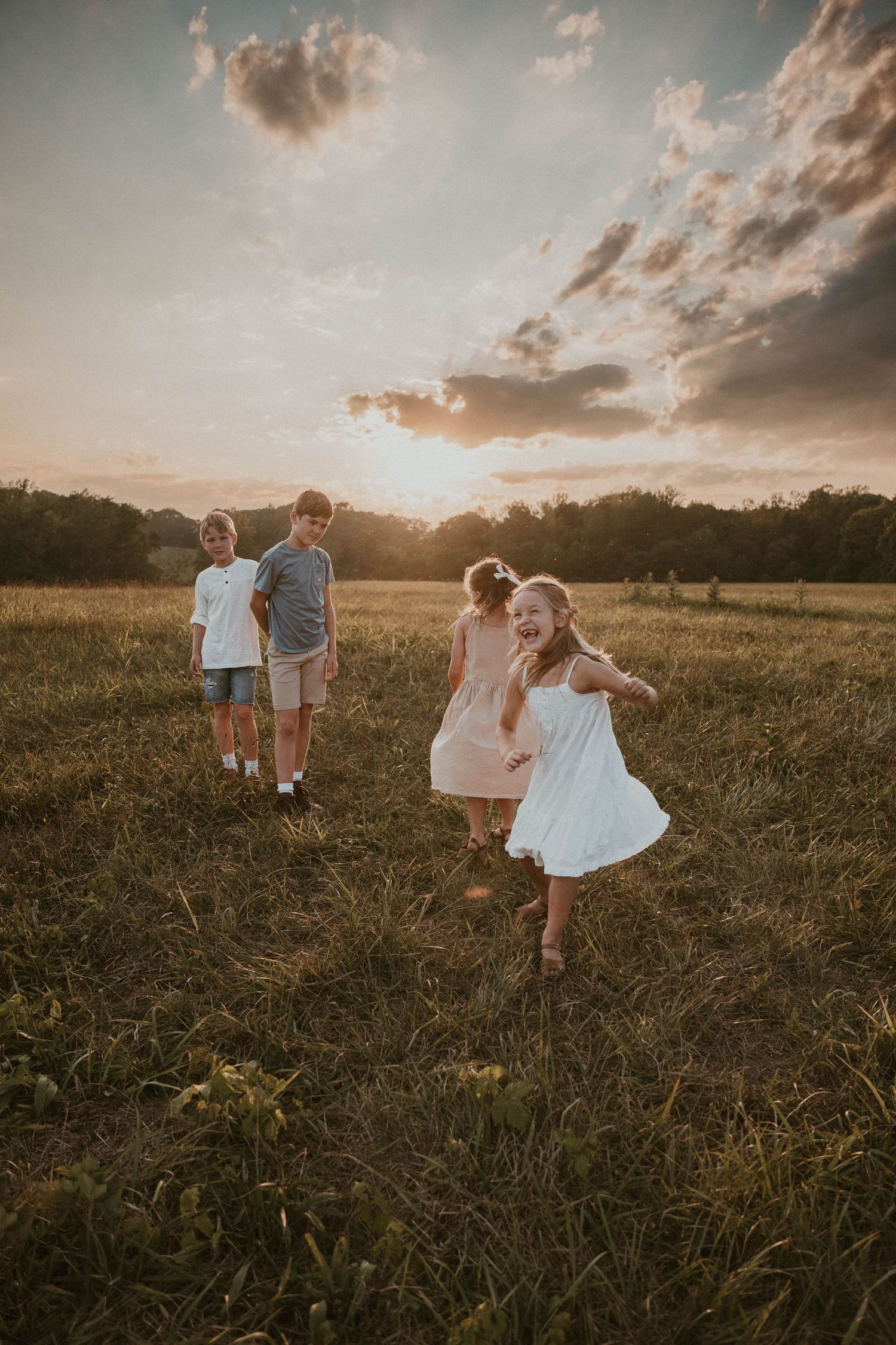 Silhouettes of family members playing in field during sunset.