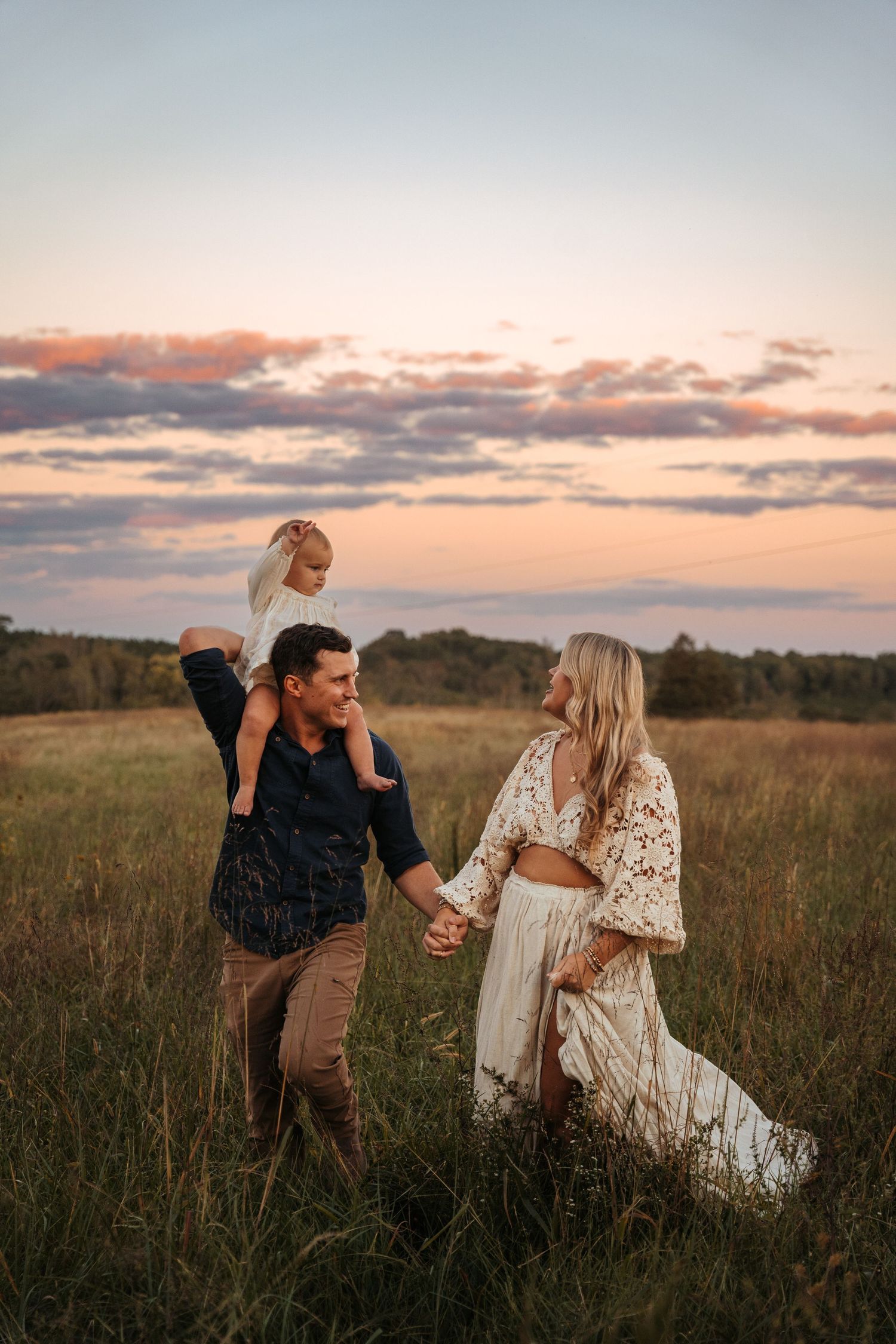 Playful family interactions captured in a golden meadow at dusk.