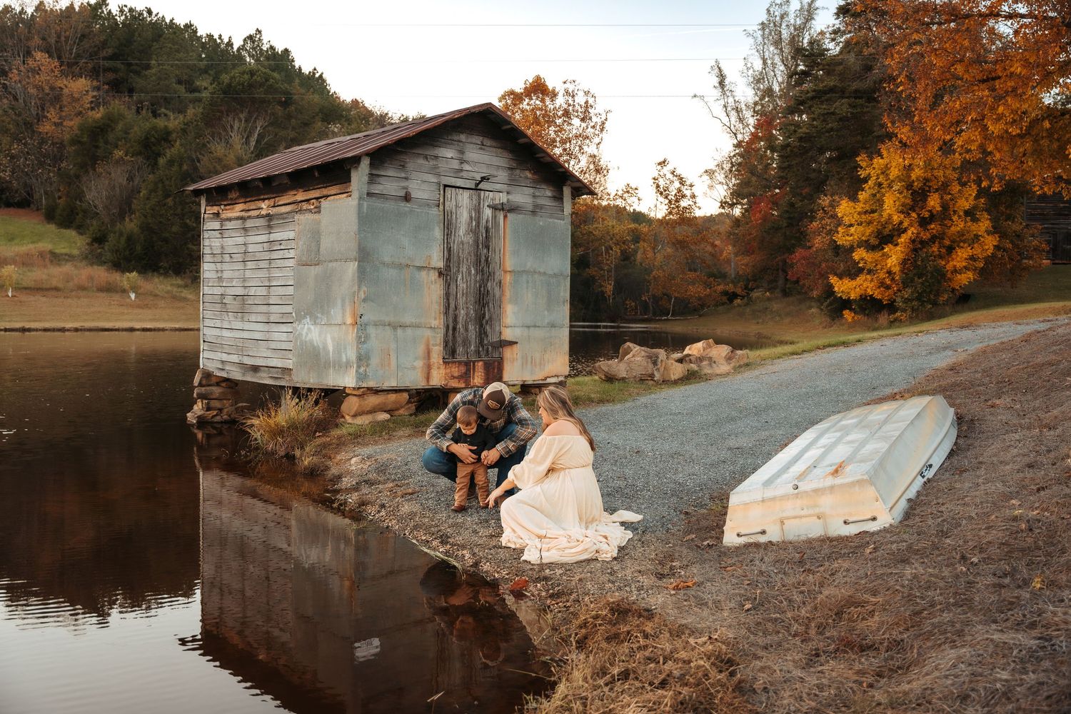 Rustic barn and pond setting with autumn foliage creating a romantic countryside atmosphere.