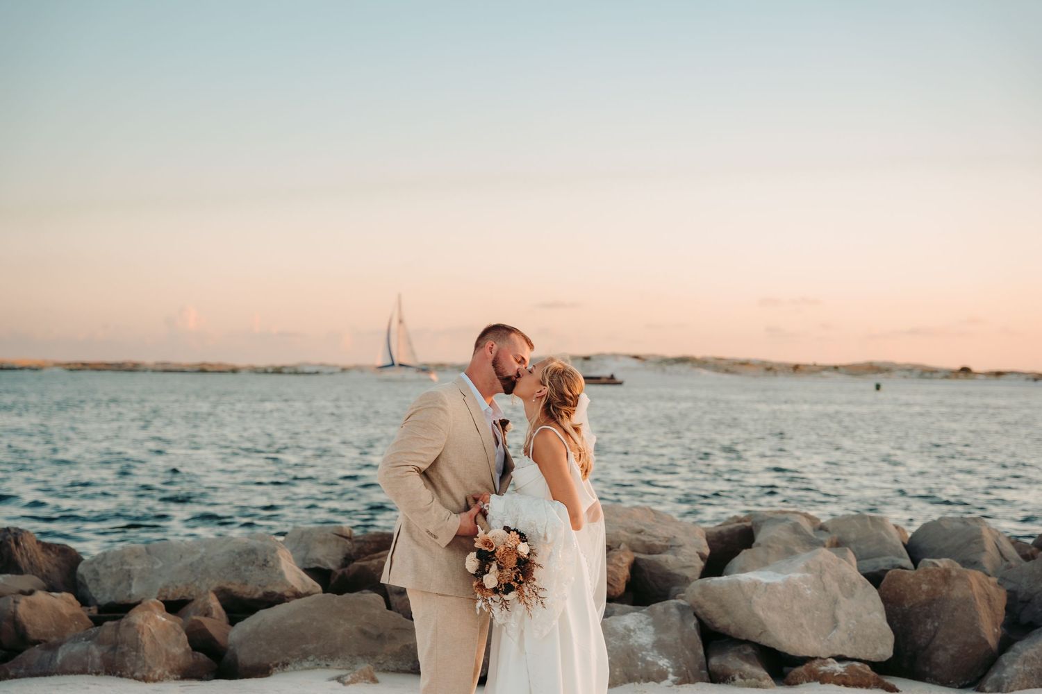 Sunset beach wedding portrait session along rocky coastline.