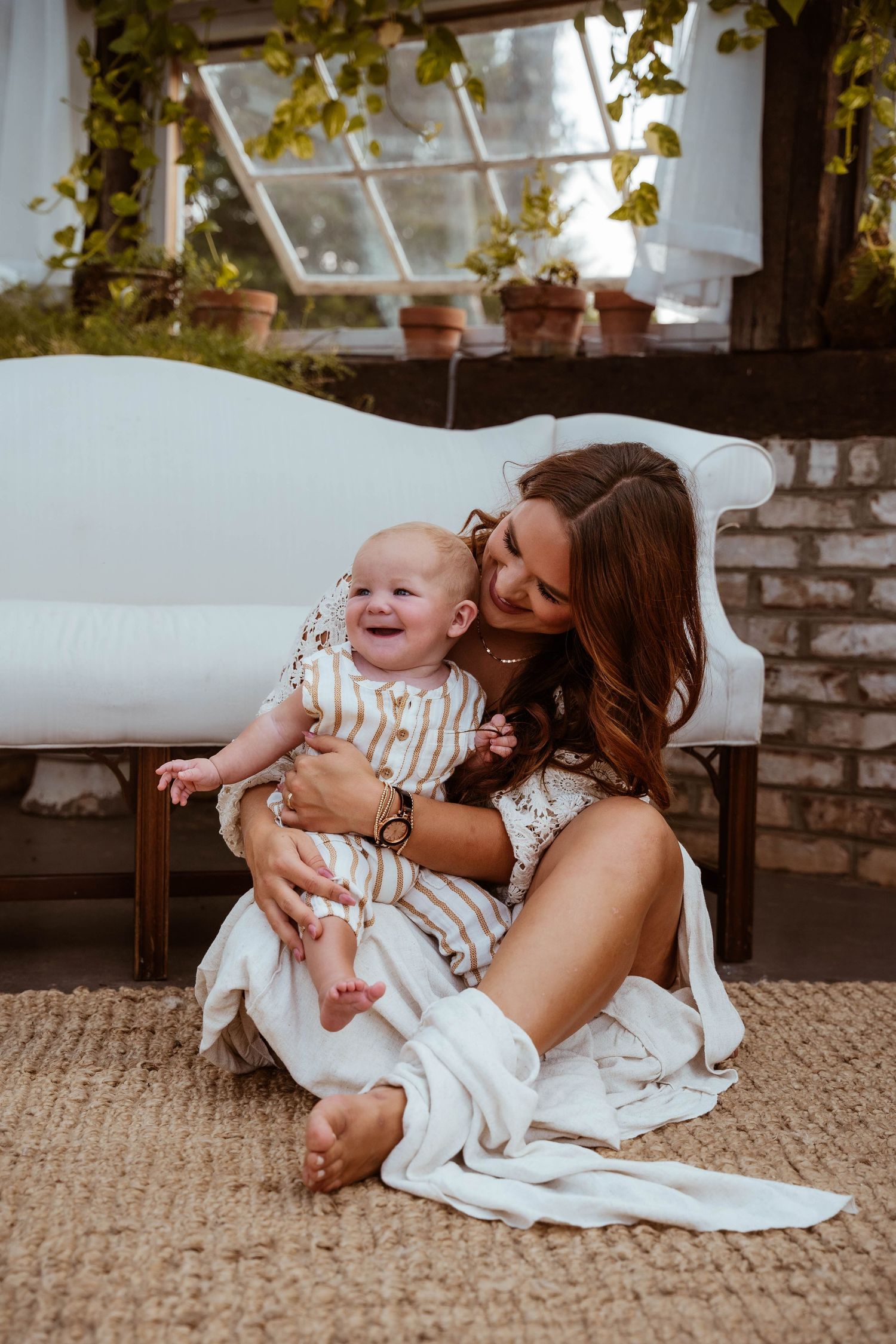 A heartwarming moment on a white couch with natural window light and greenery.