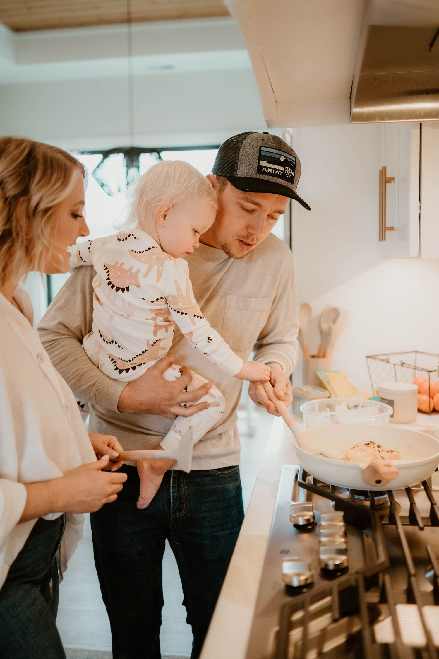 A family shares playful moments while cooking together in their kitchen.