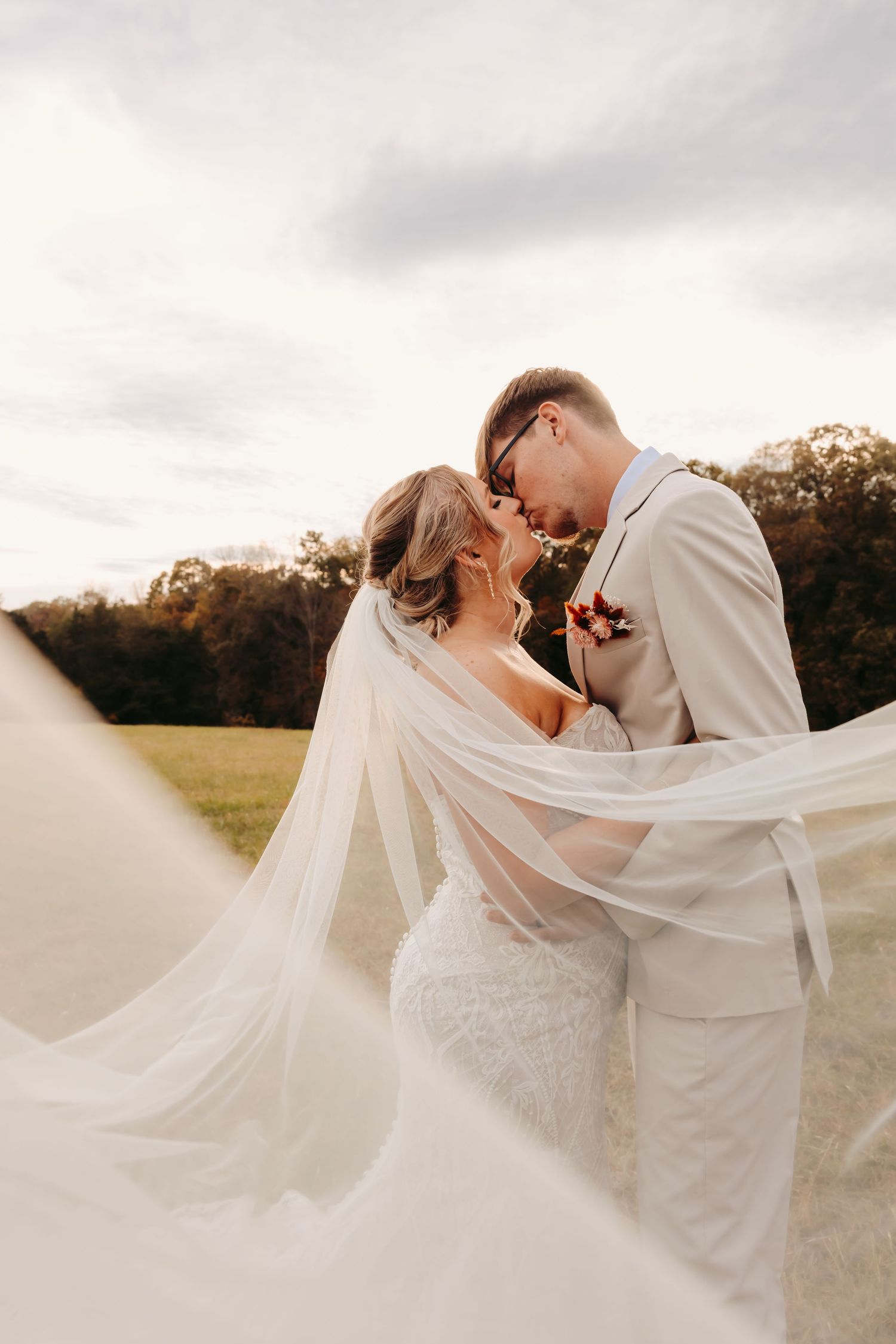 Romantic wedding portrait with flowing veil in soft natural light.