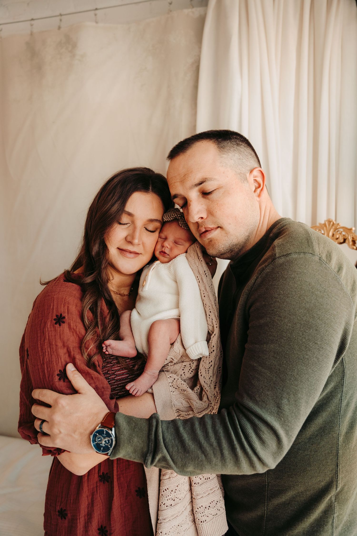 Intimate family portrait session with soft neutral tones and gentle embraces.
