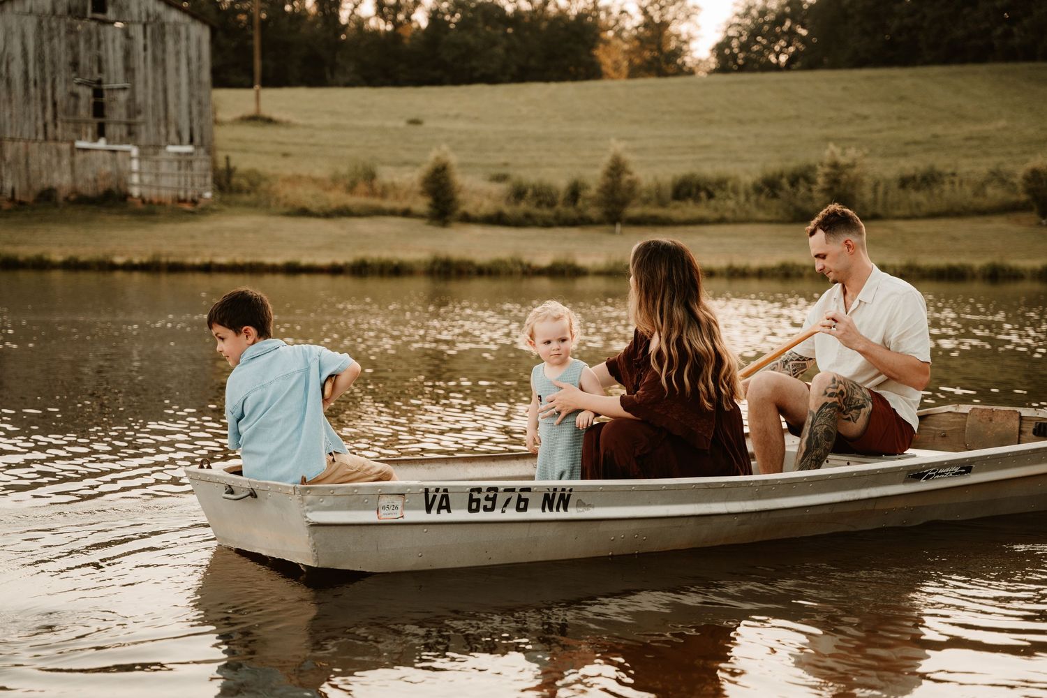 Group enjoying a peaceful boat ride on lake during golden hour.