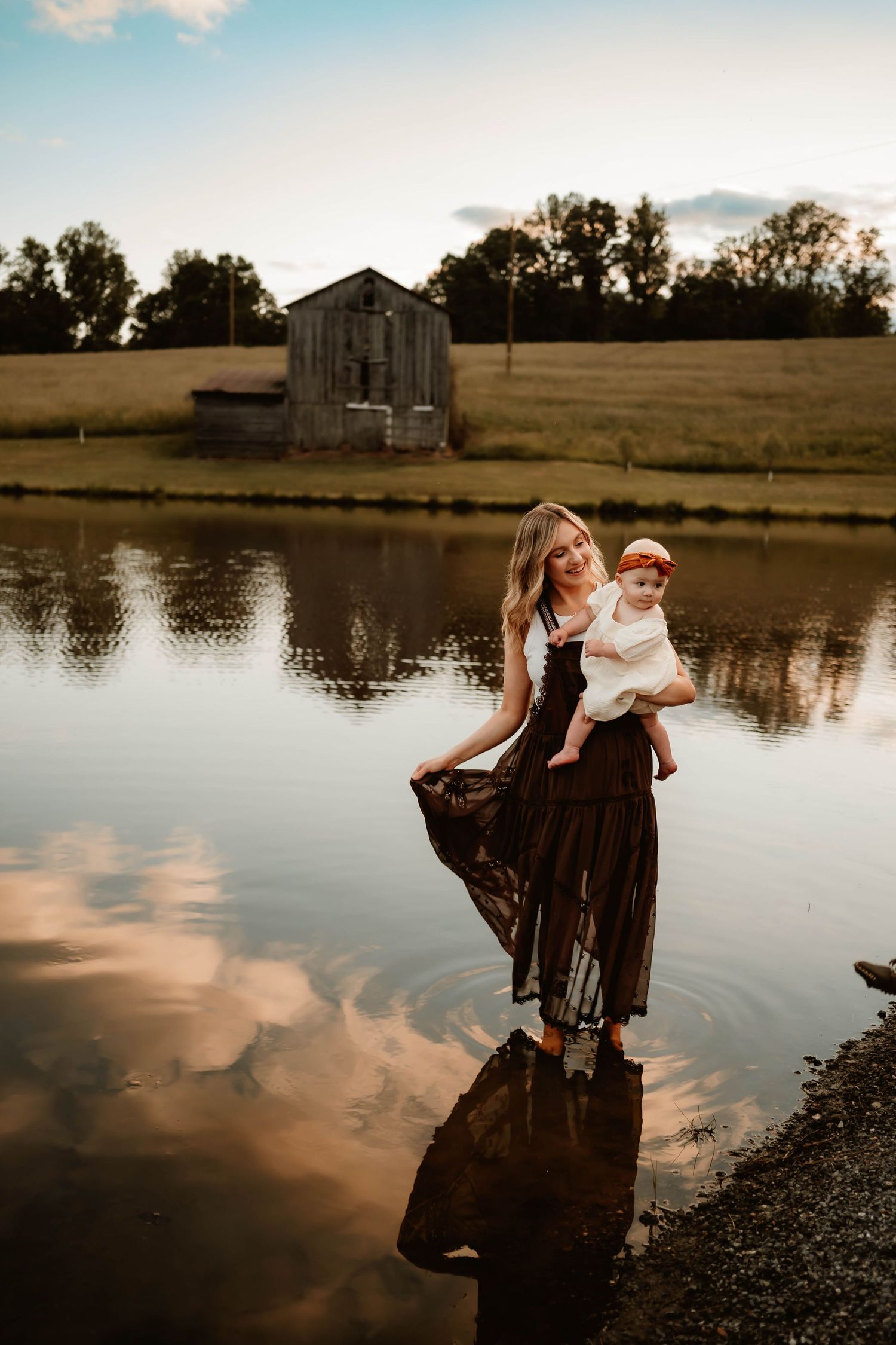 A scenic lakeside photoshoot at sunset with reflections in the calm water.