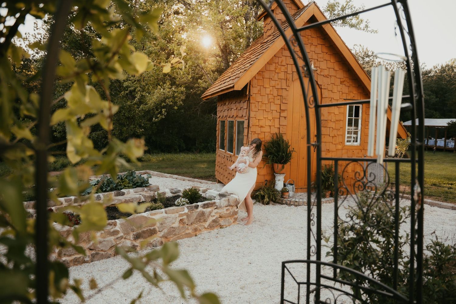 A rustic brick building with white trim sits nestled among autumn foliage.