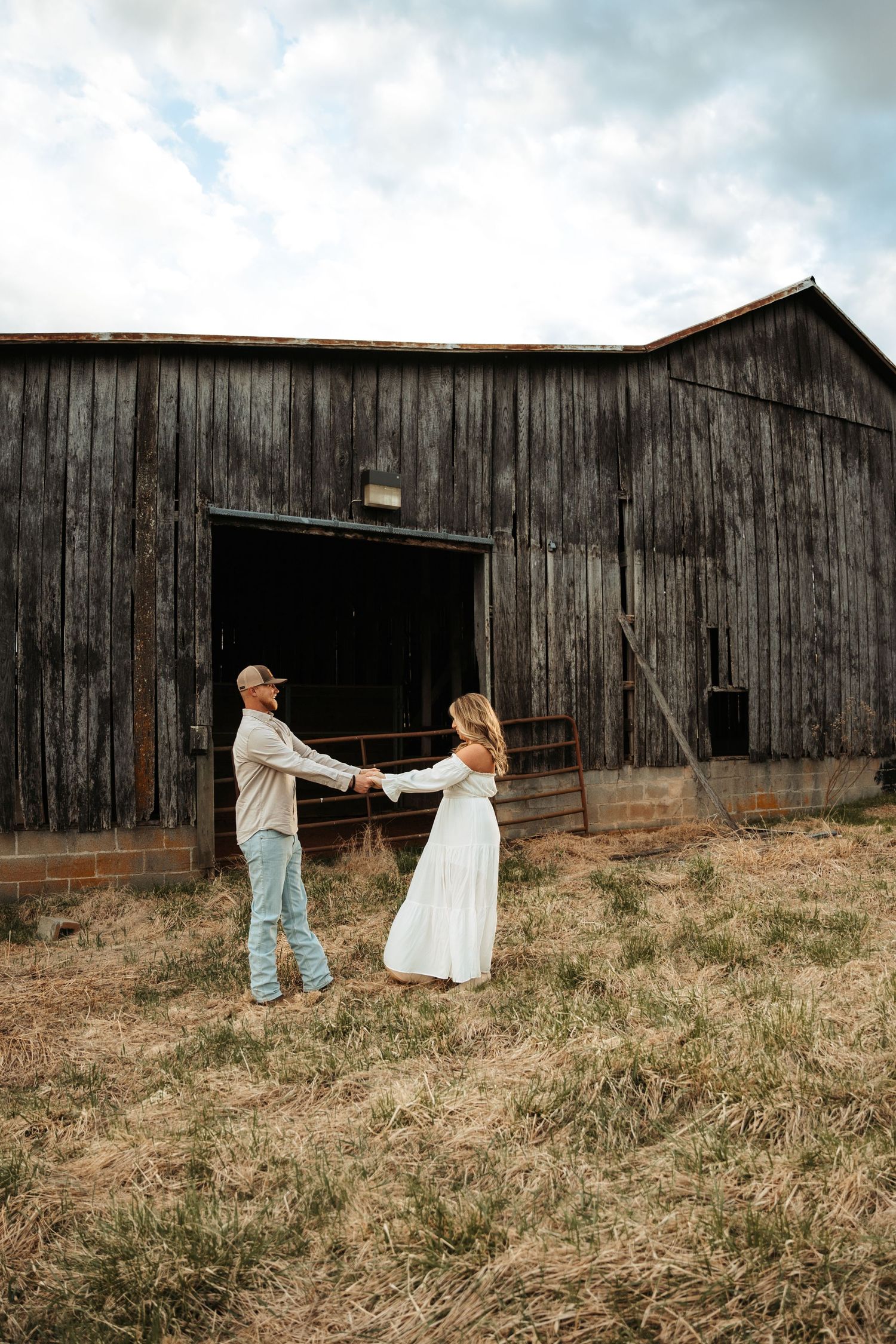 A rustic barn serves as backdrop for an artistic dress photoshoot.
