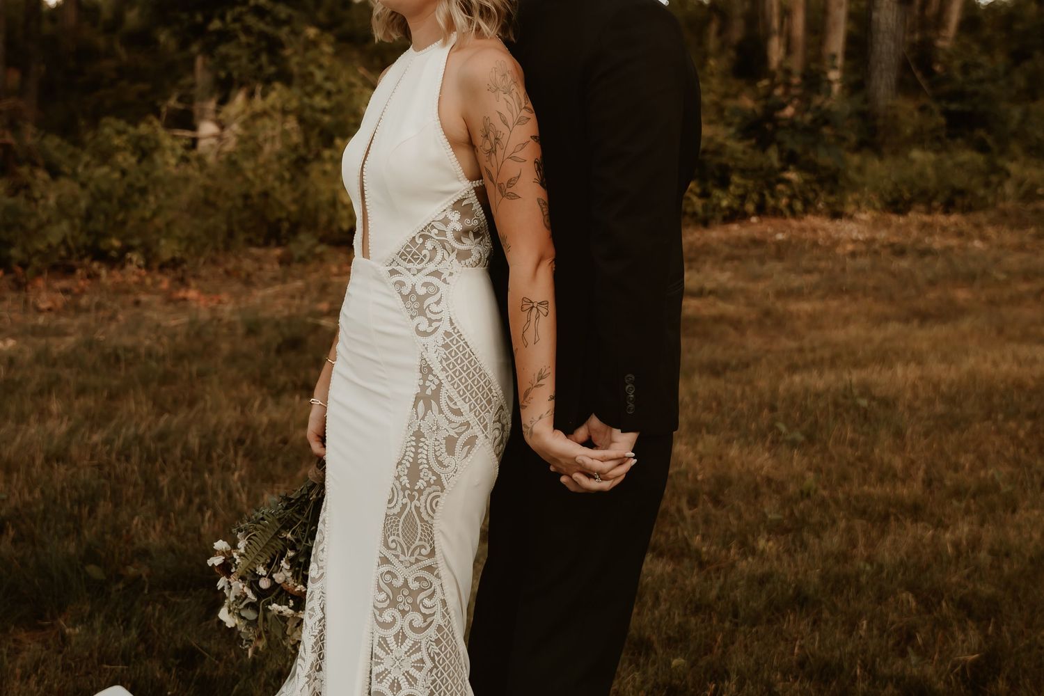 A romantic wedding photo shoot in a wooded area with golden sunlight filtering through the trees.