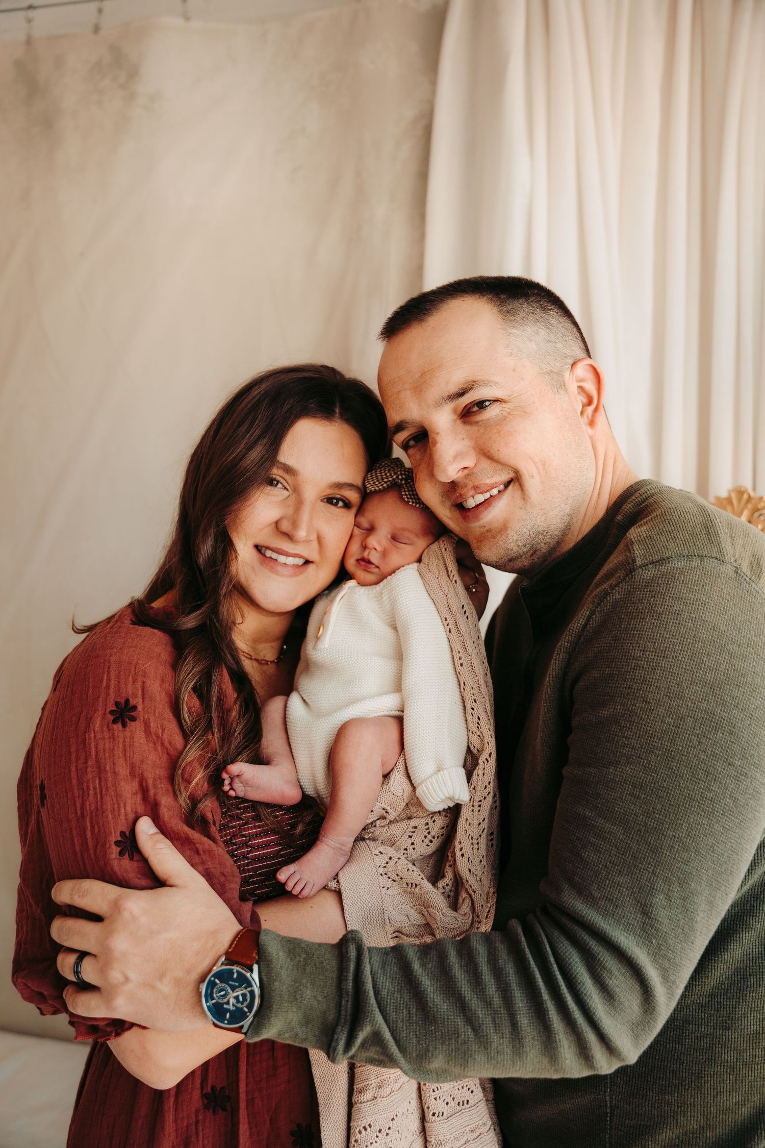 Indoor family portrait session with neutral colors showing tender moments together.