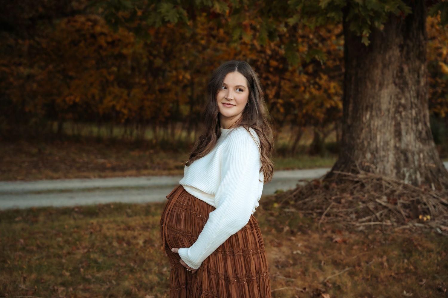 Autumn outdoor portrait session among fallen leaves and trees.