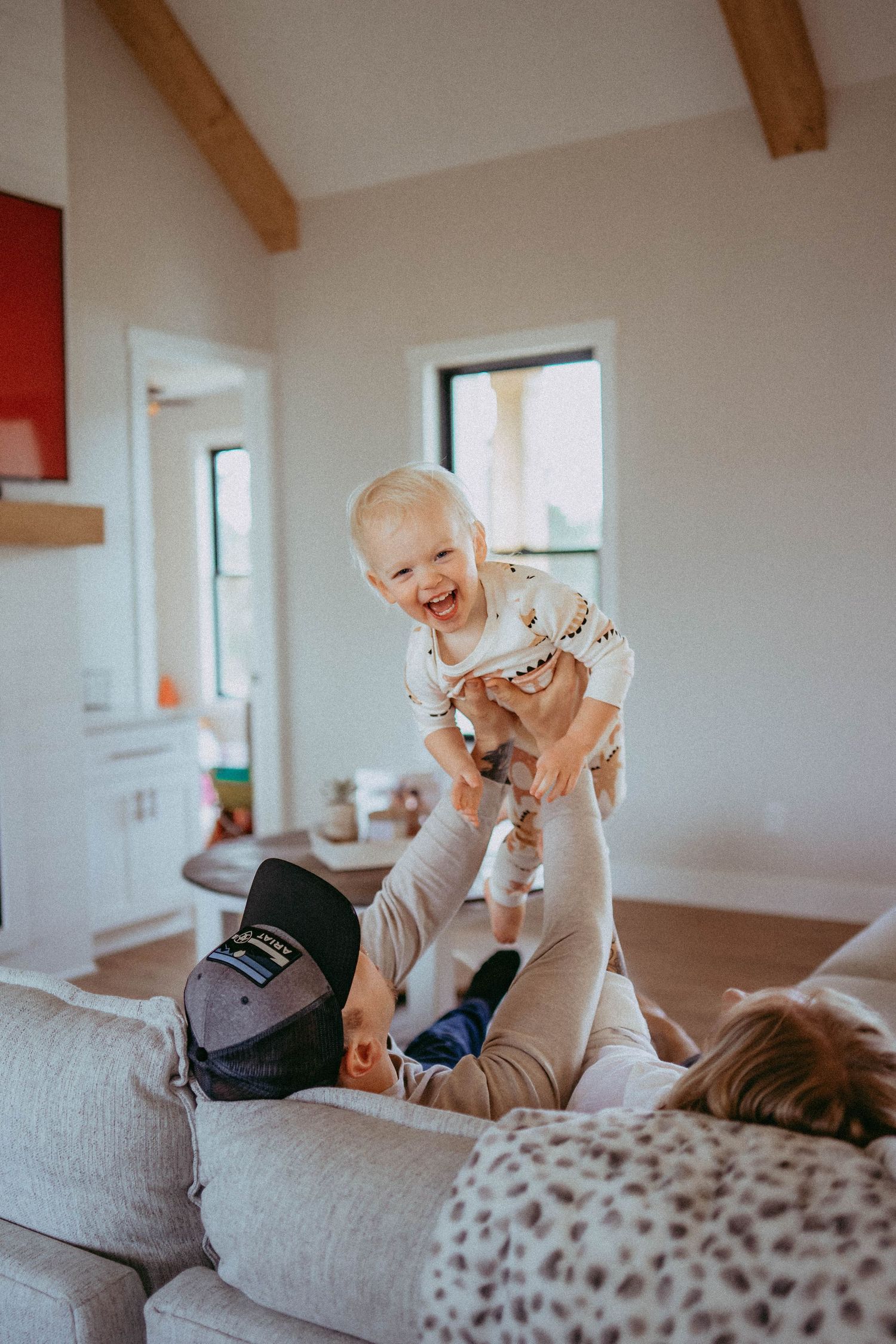 Joyful playtime moments captured on a light gray sofa in a bright room.