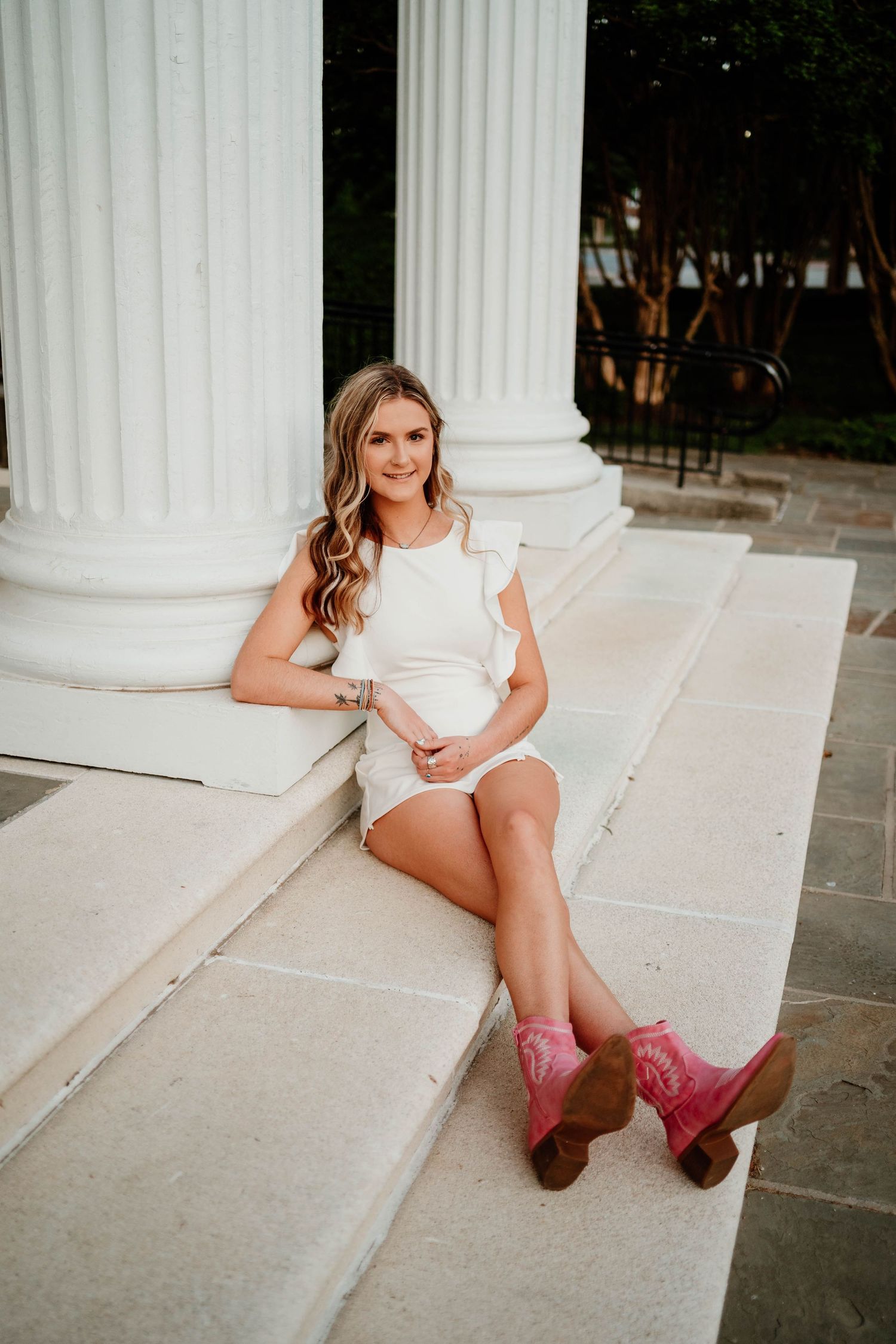 White columns frame a casual portrait session featuring pink western boots.