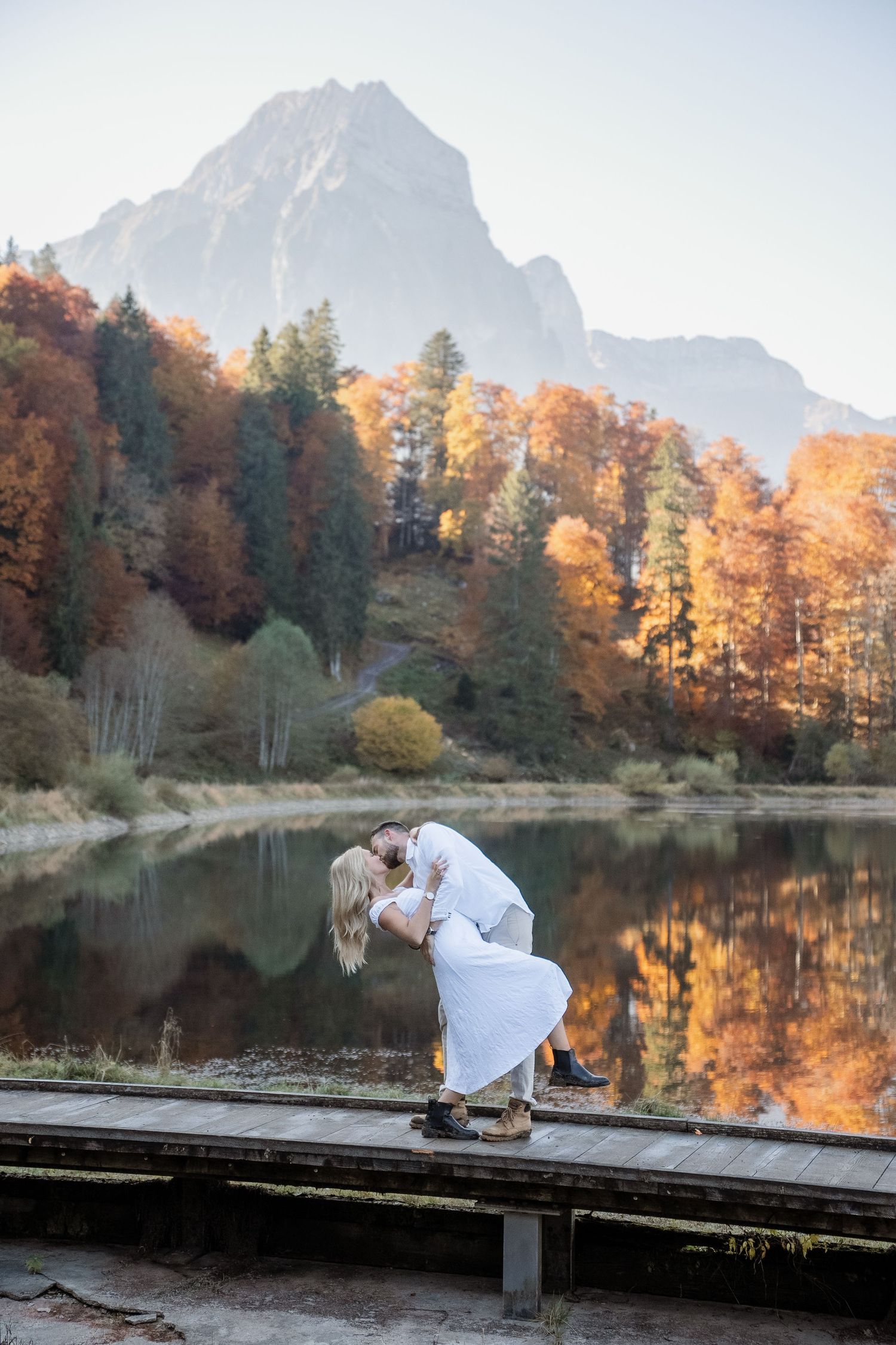Paar vor einem Bergsee. Herbstmoment und goldene Farben.