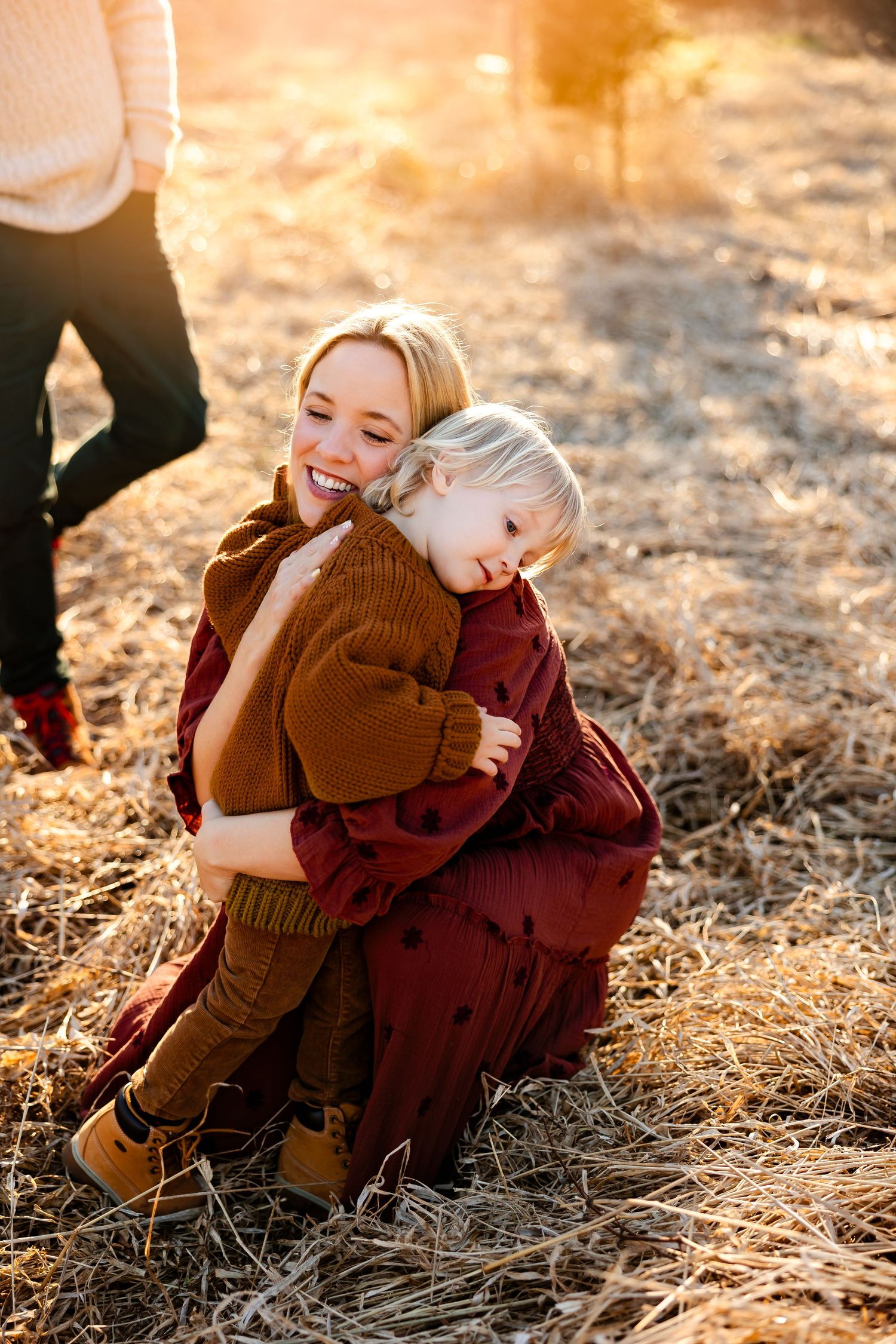 A tender embrace captured in warm autumn sunlight on dried grass.